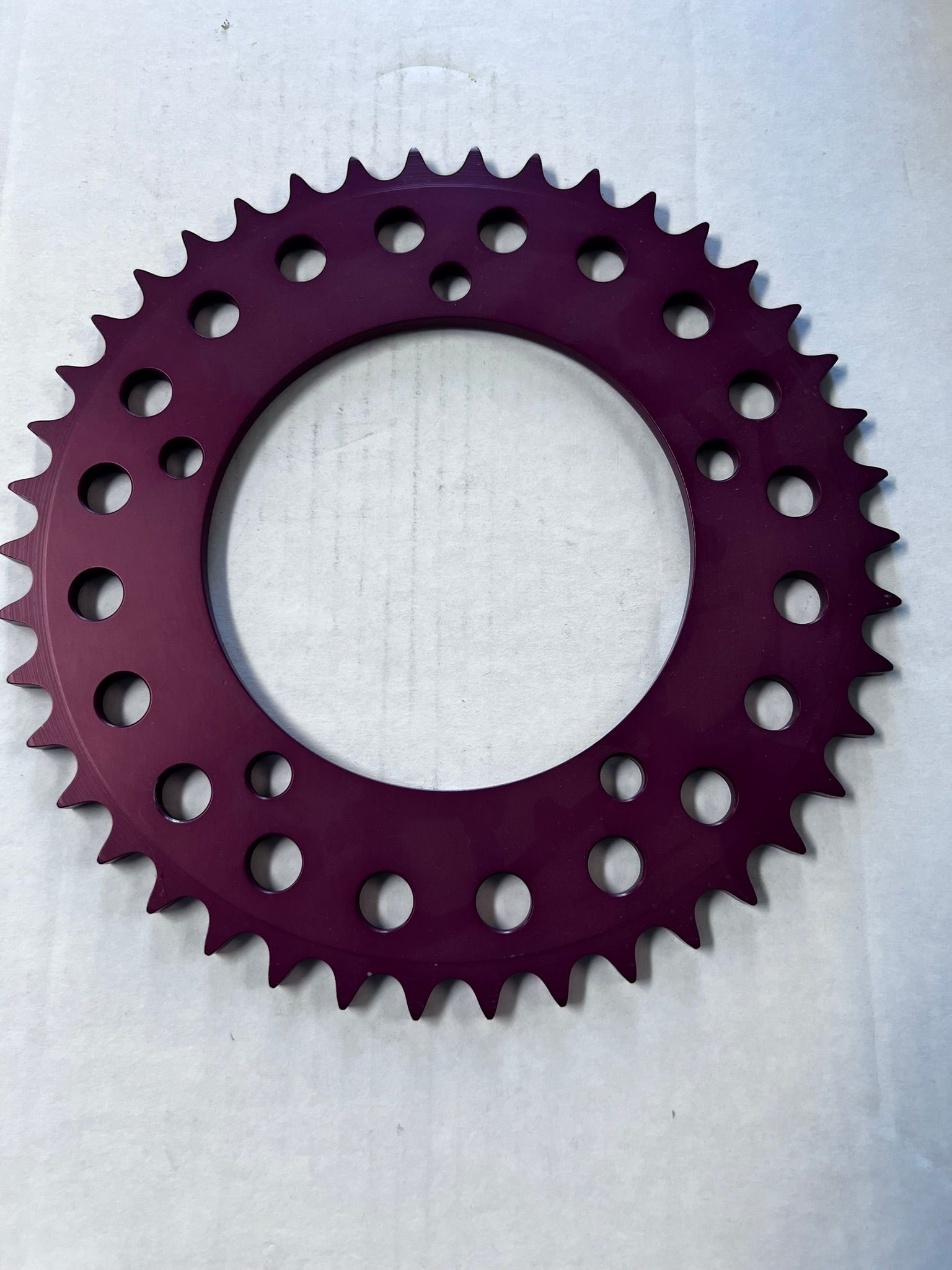 A purple ring with holes in it is on a white surface