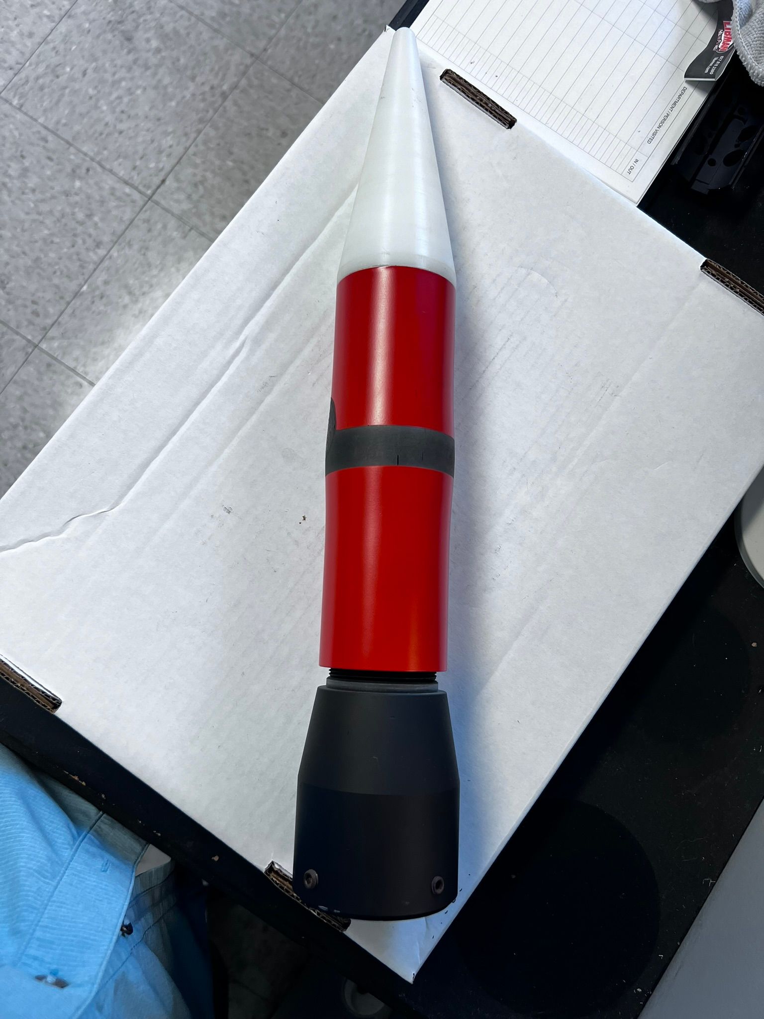 A red and white rocket is sitting on top of a white box.