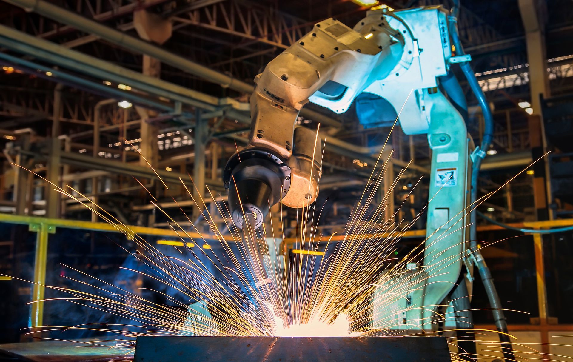 A robot is welding a piece of metal in a factory.