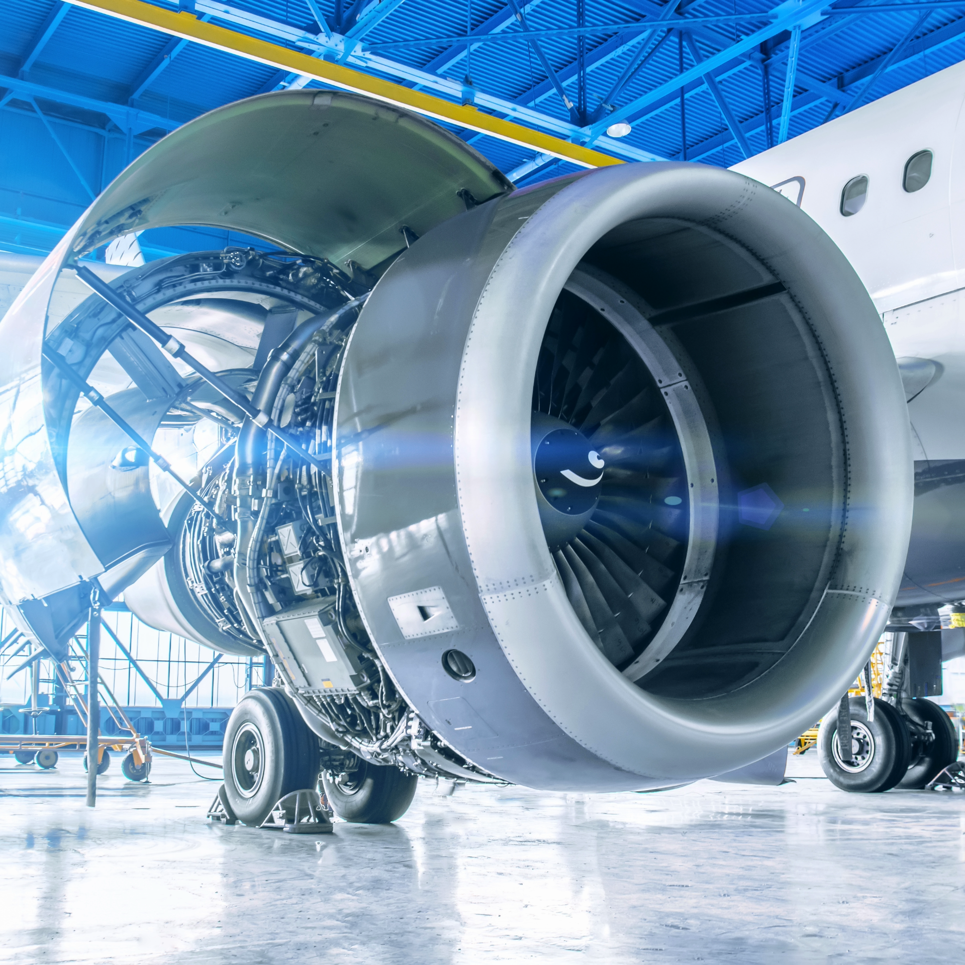 The engine of an airplane is sitting in a hangar.