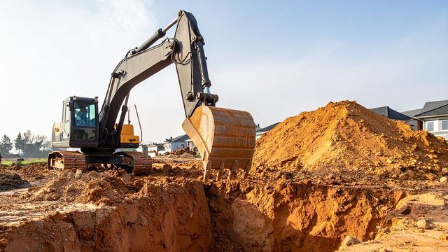 Swimming pool removal Phoenix with excavator and dump trailer