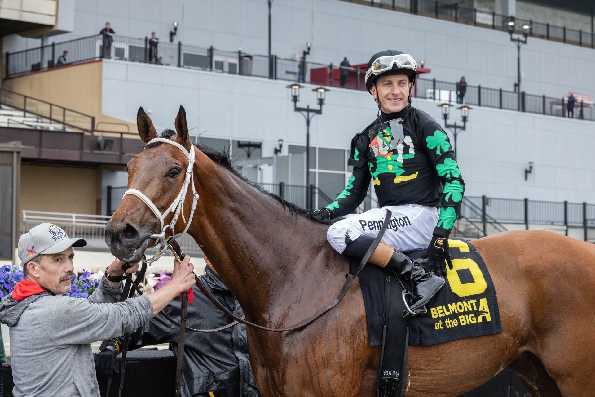 Horse race with three jockeys and galloping horses kicking up dirt at the finish line