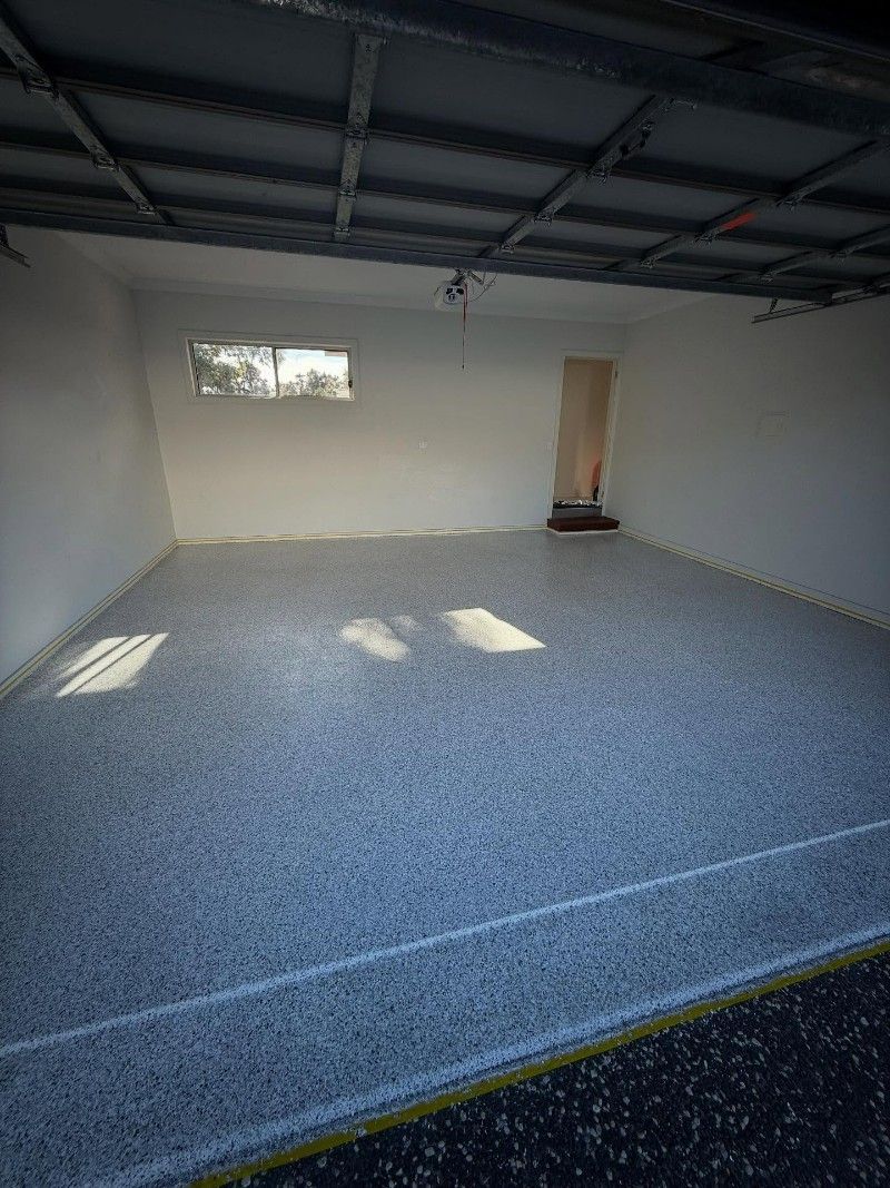 An Empty Garage With a Concrete Floor and White Walls — Premier Epoxy Flooring Wollongong in Wollongong, NSW