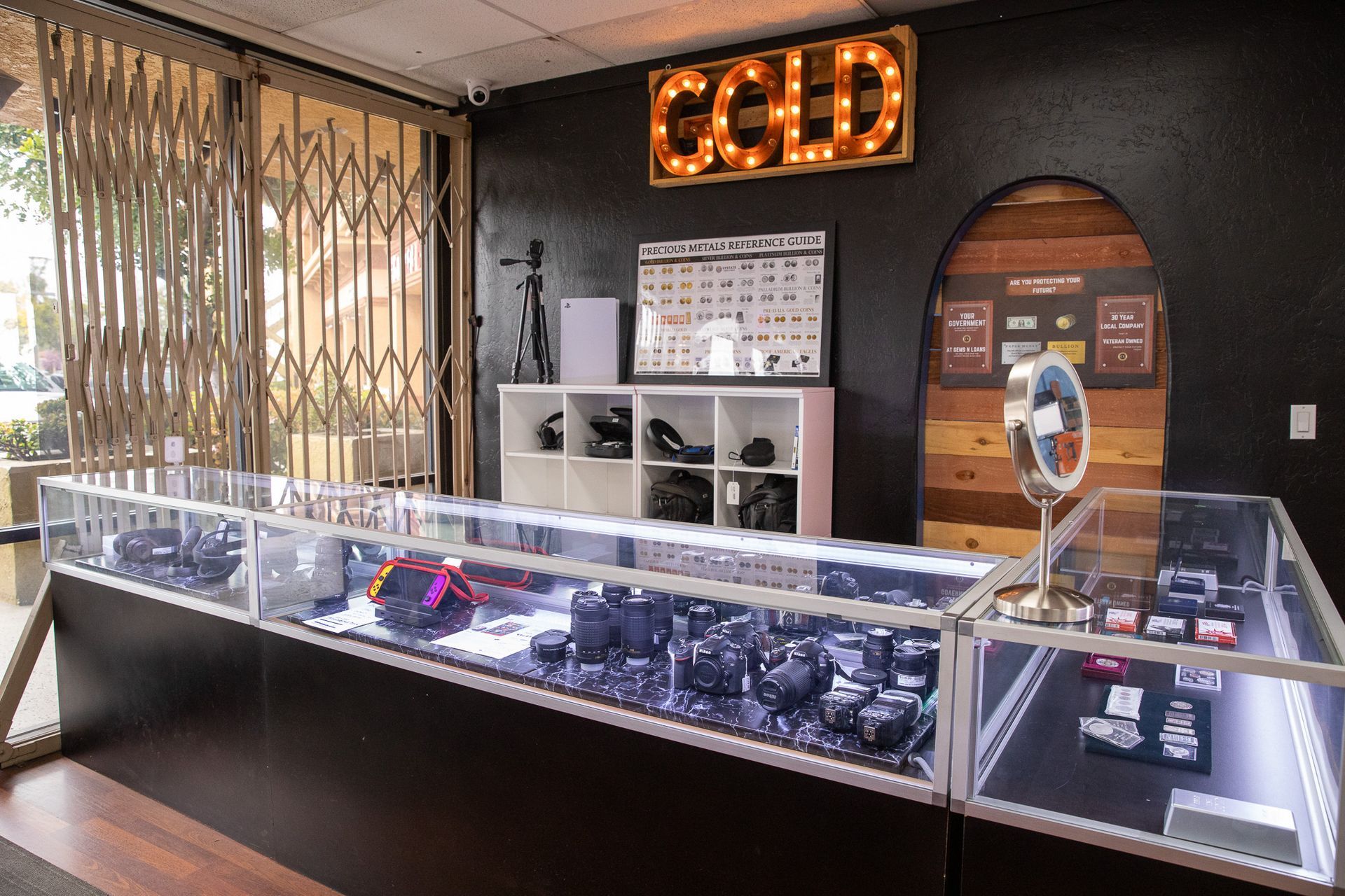 Jewelry store counter with glass display cases and a glowing gold “GOLD” sign on the back wall