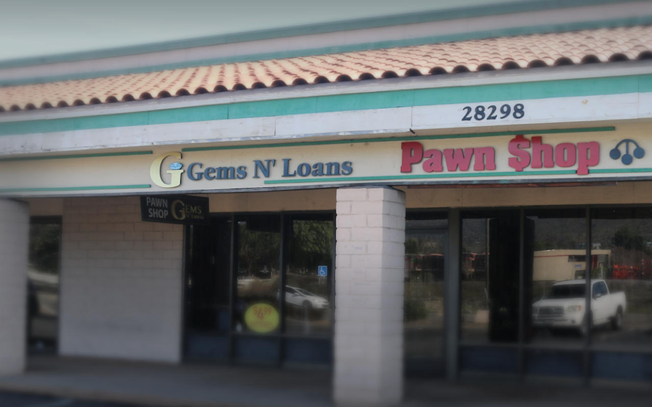 A pawn shop with a sign that says gems n loans