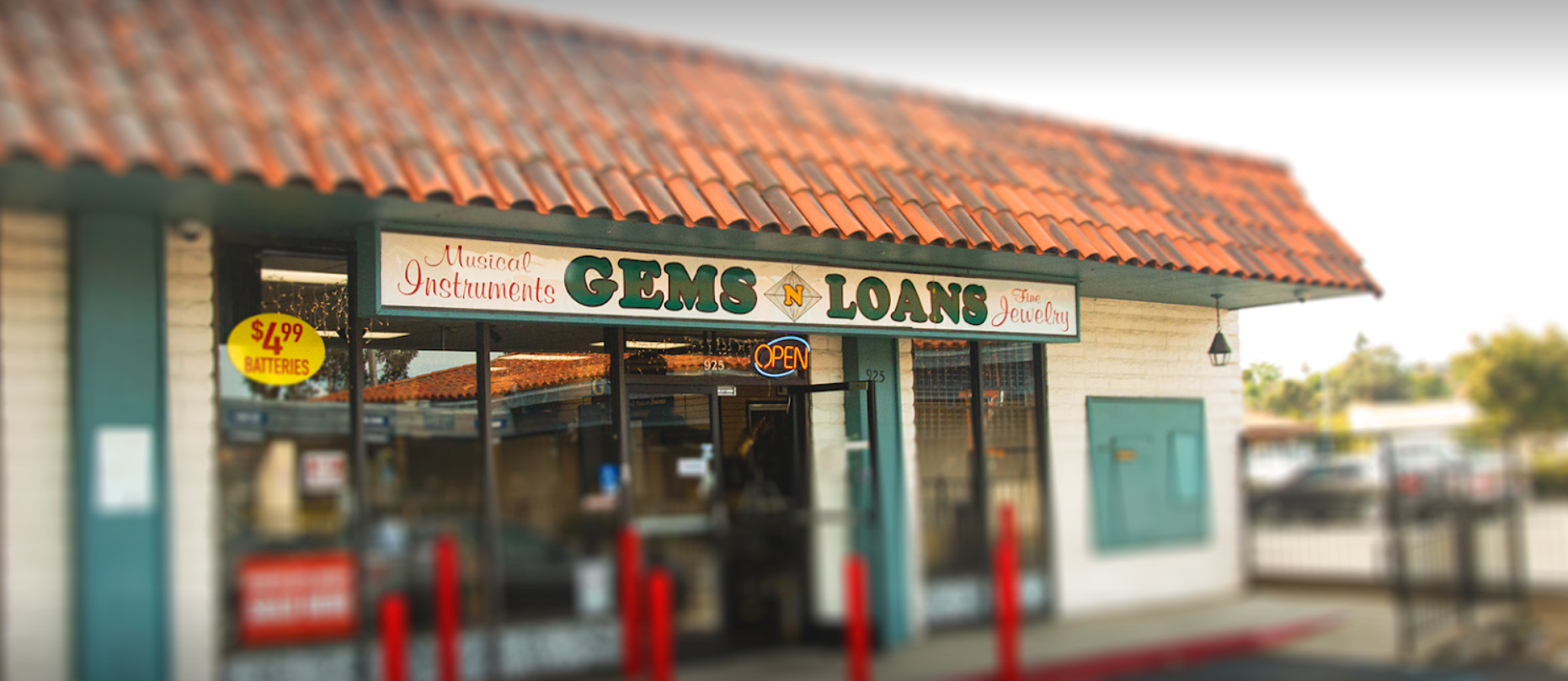 A store front with a sign that says ' gems & loans ' on it