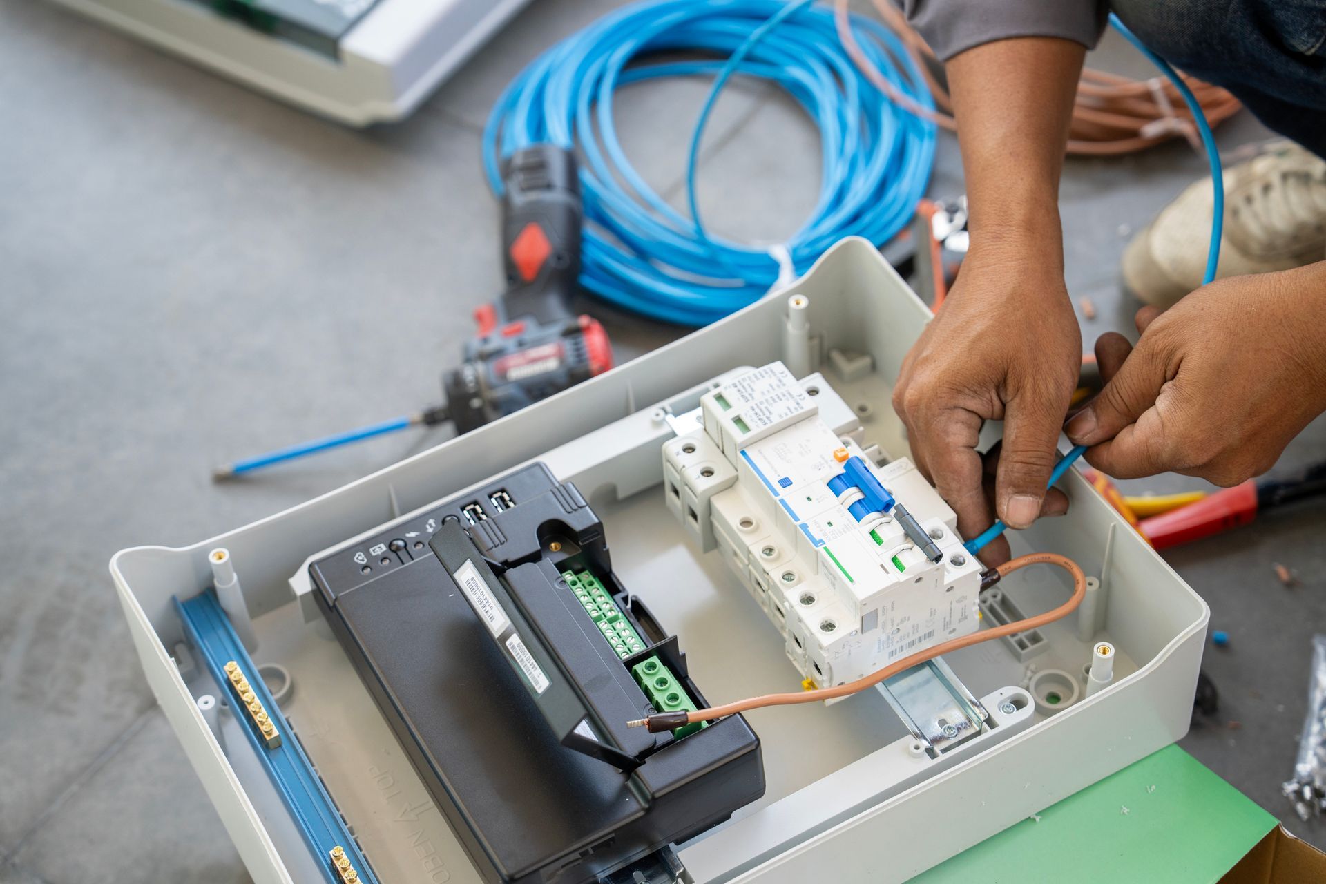 Technician connecting wires for an electrical power system maintenance.