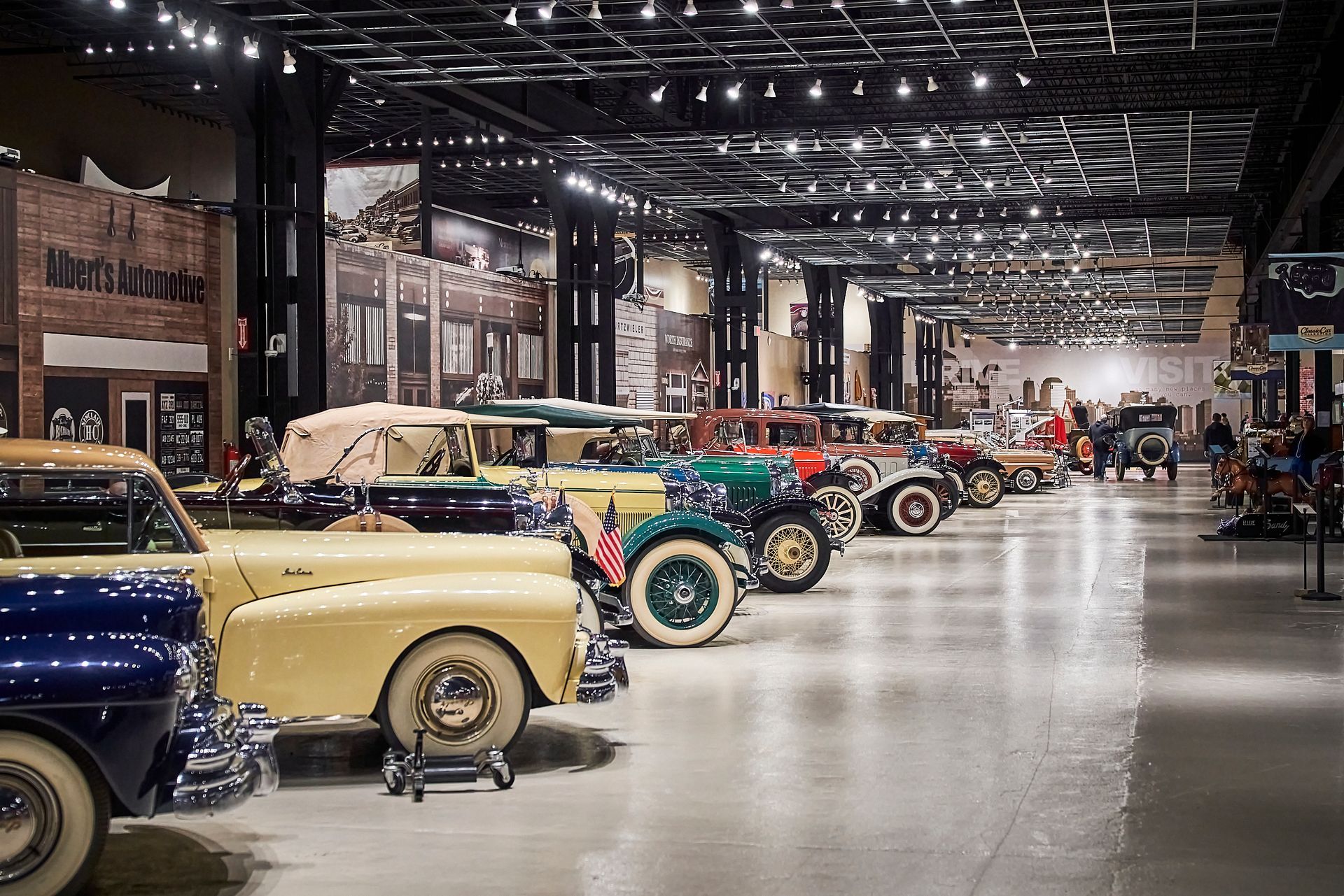 A row of old cars are parked in a museum.