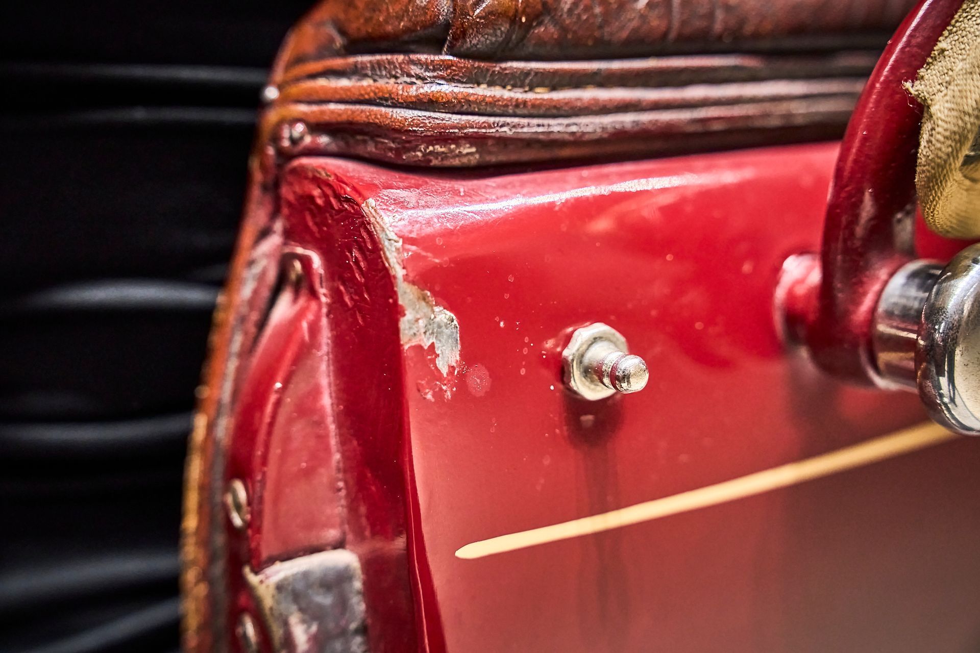A close up of a red suitcase on a black background.