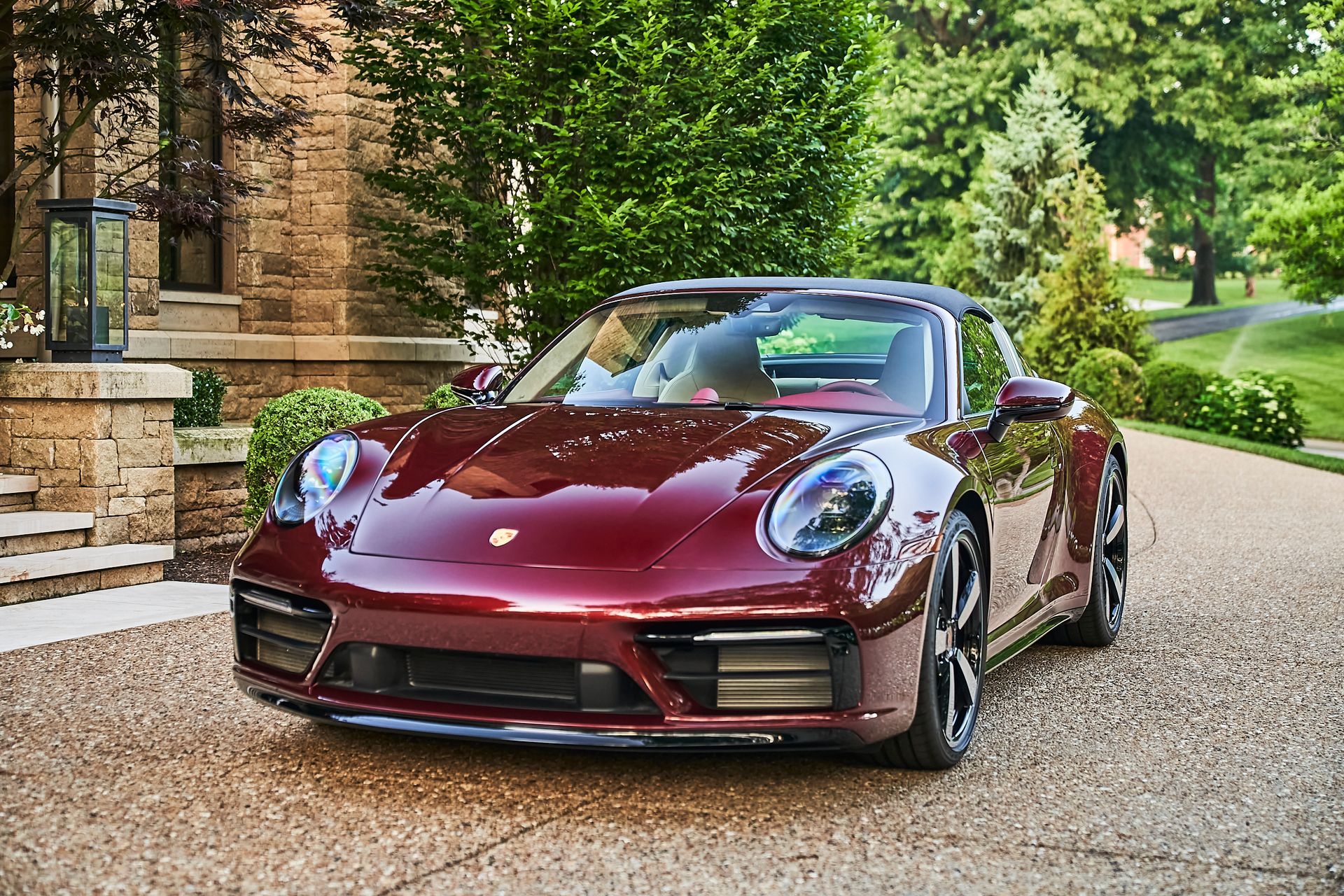 A red porsche targa is parked in front of a house.