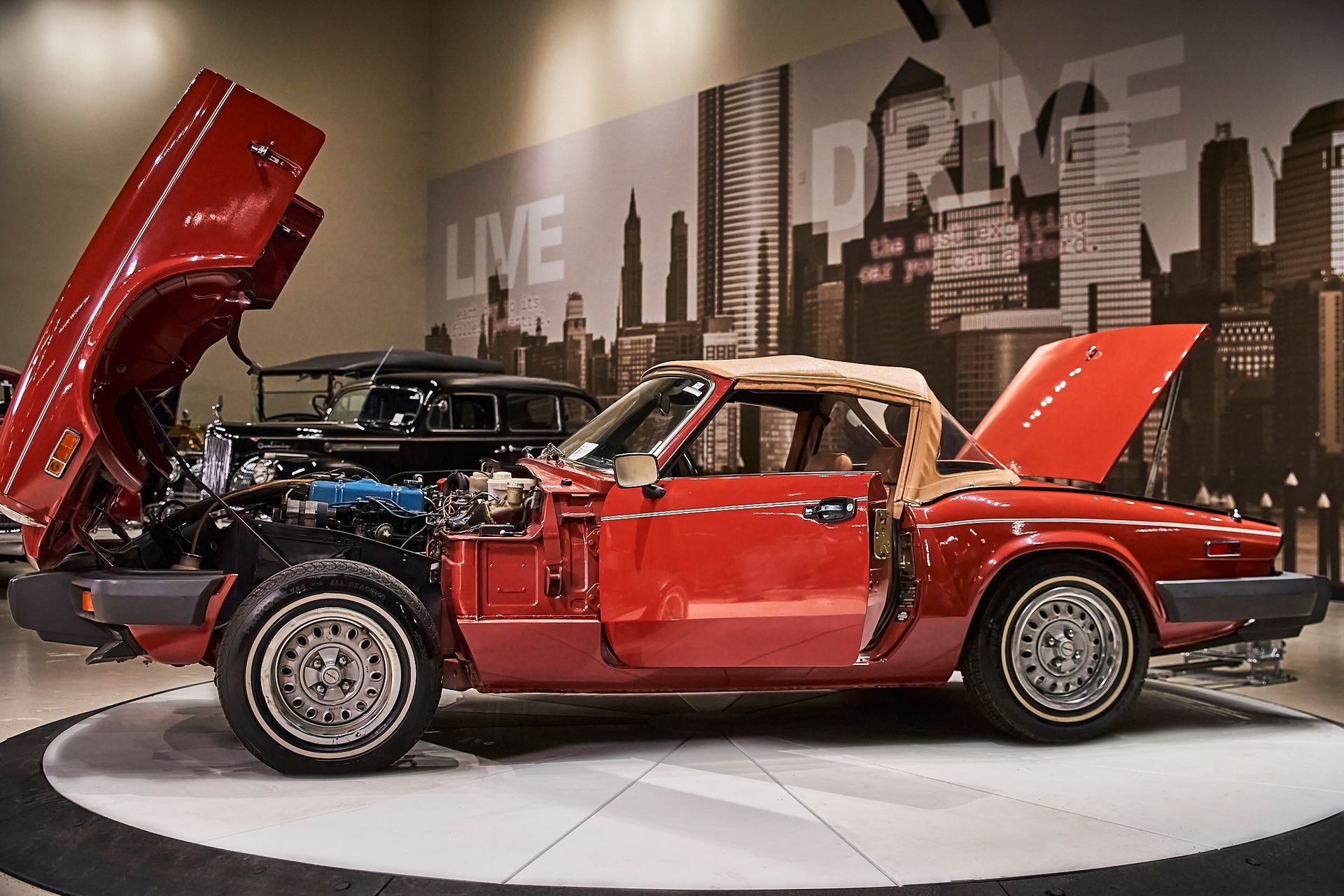 A red sports car with the hood up is on display