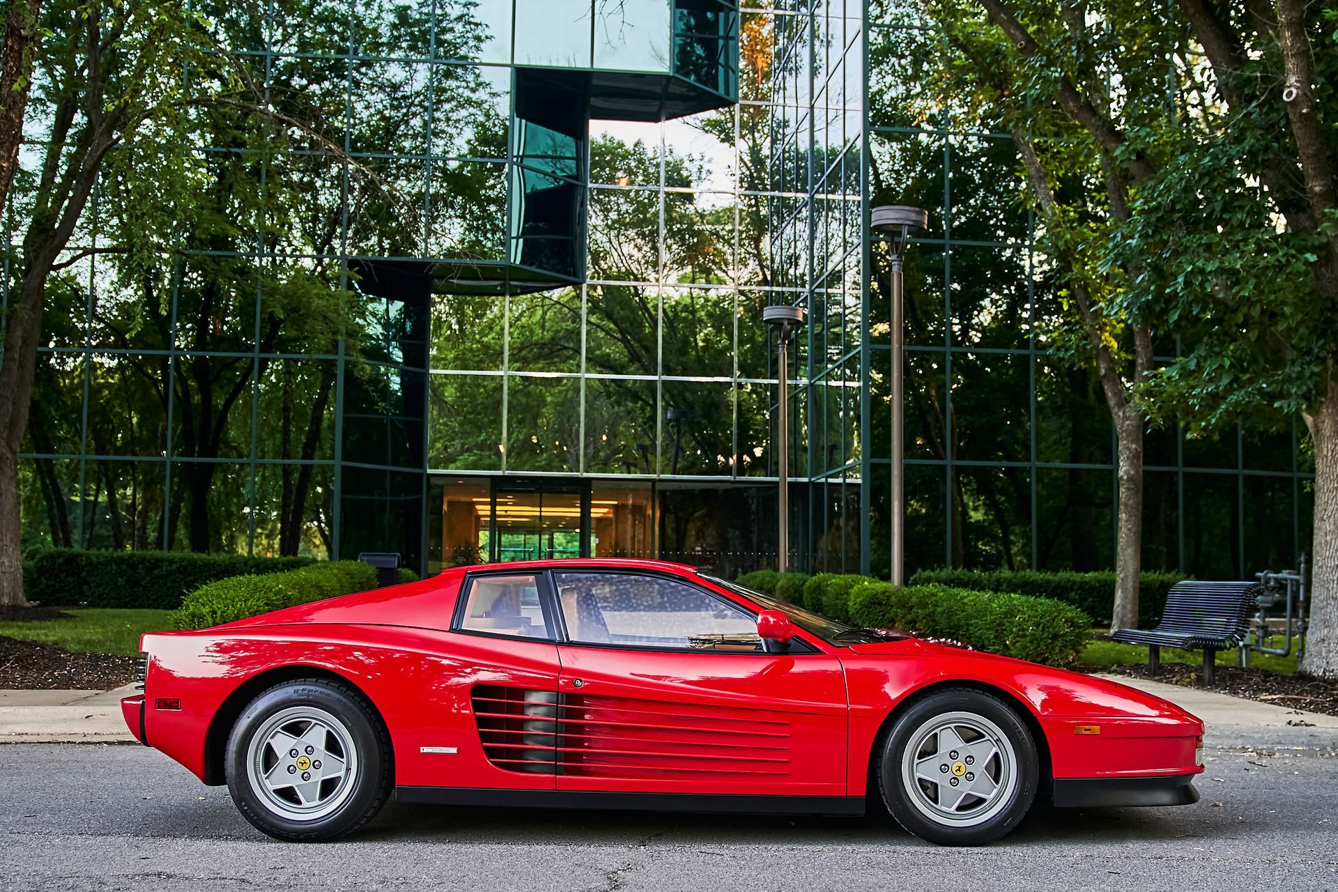 A red ferrari is parked in front of a building