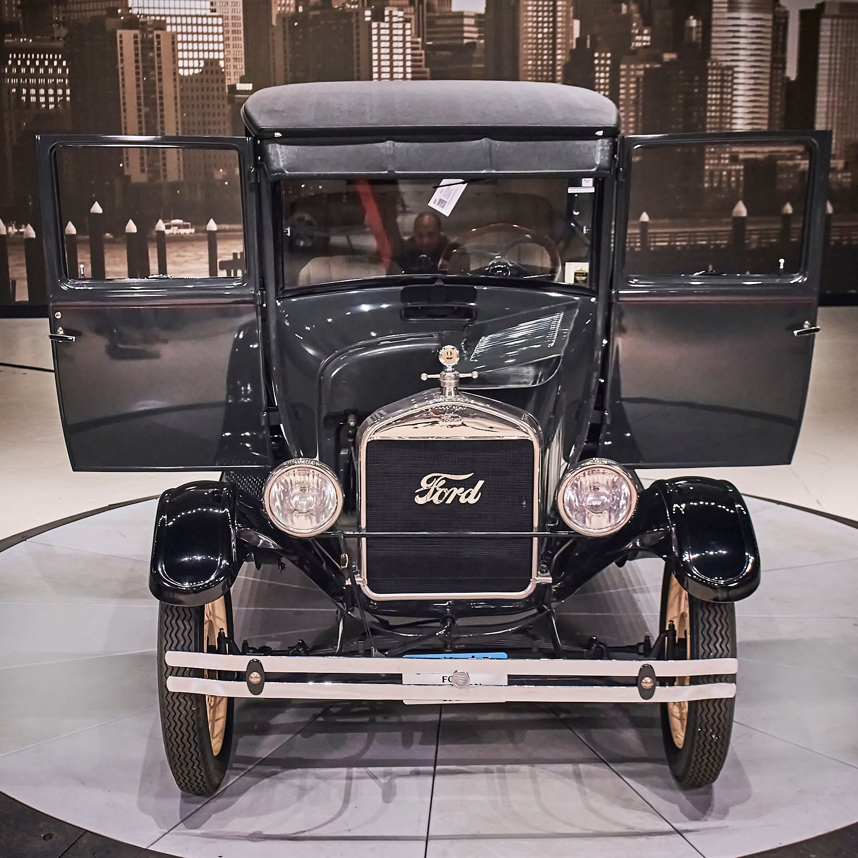An old black ford car with its doors open