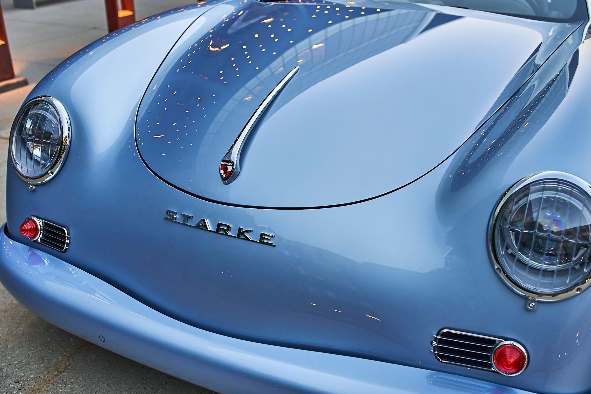 Light blue vintage car, possibly a Porsche, with
