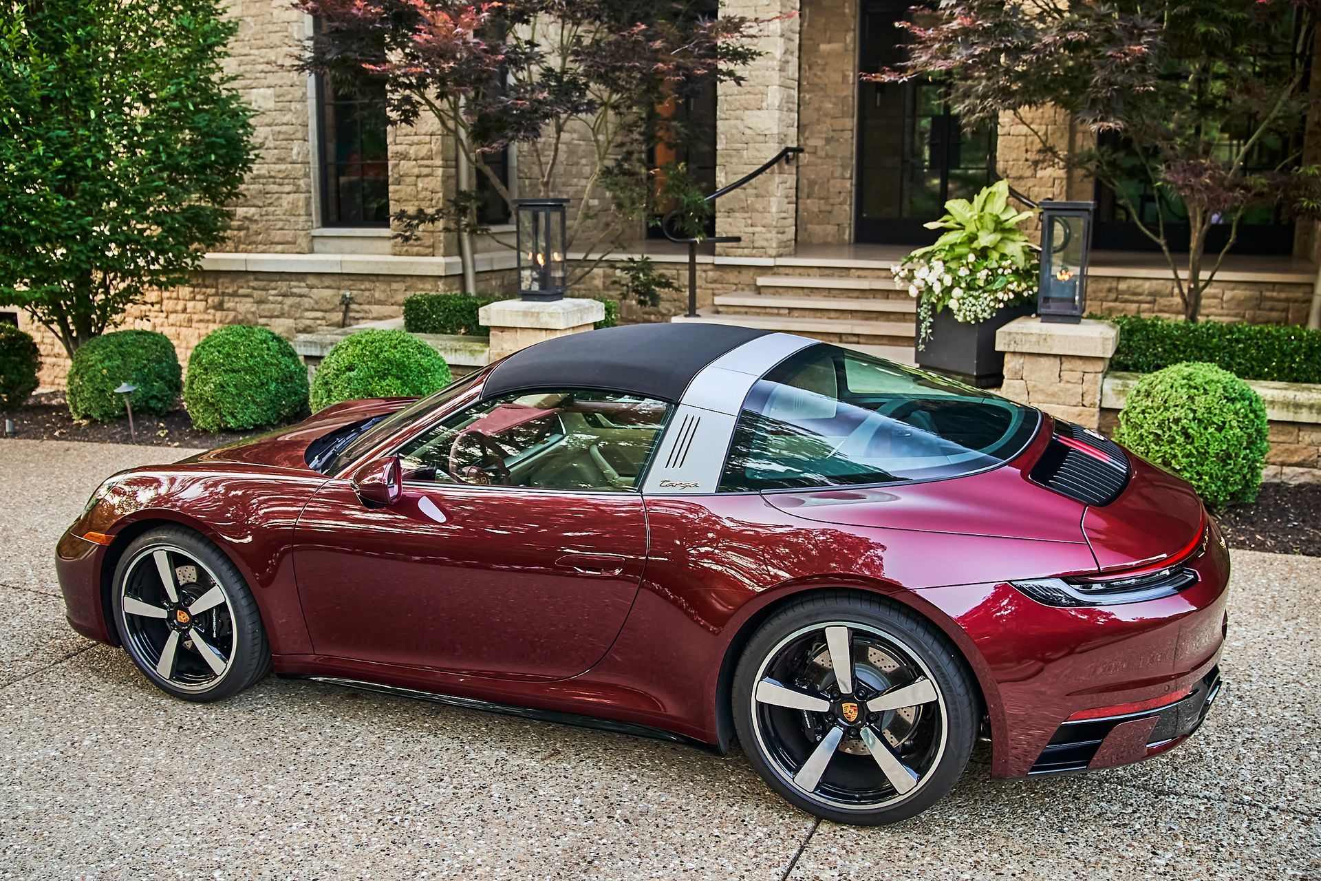 A red sports car is parked in front of a house.