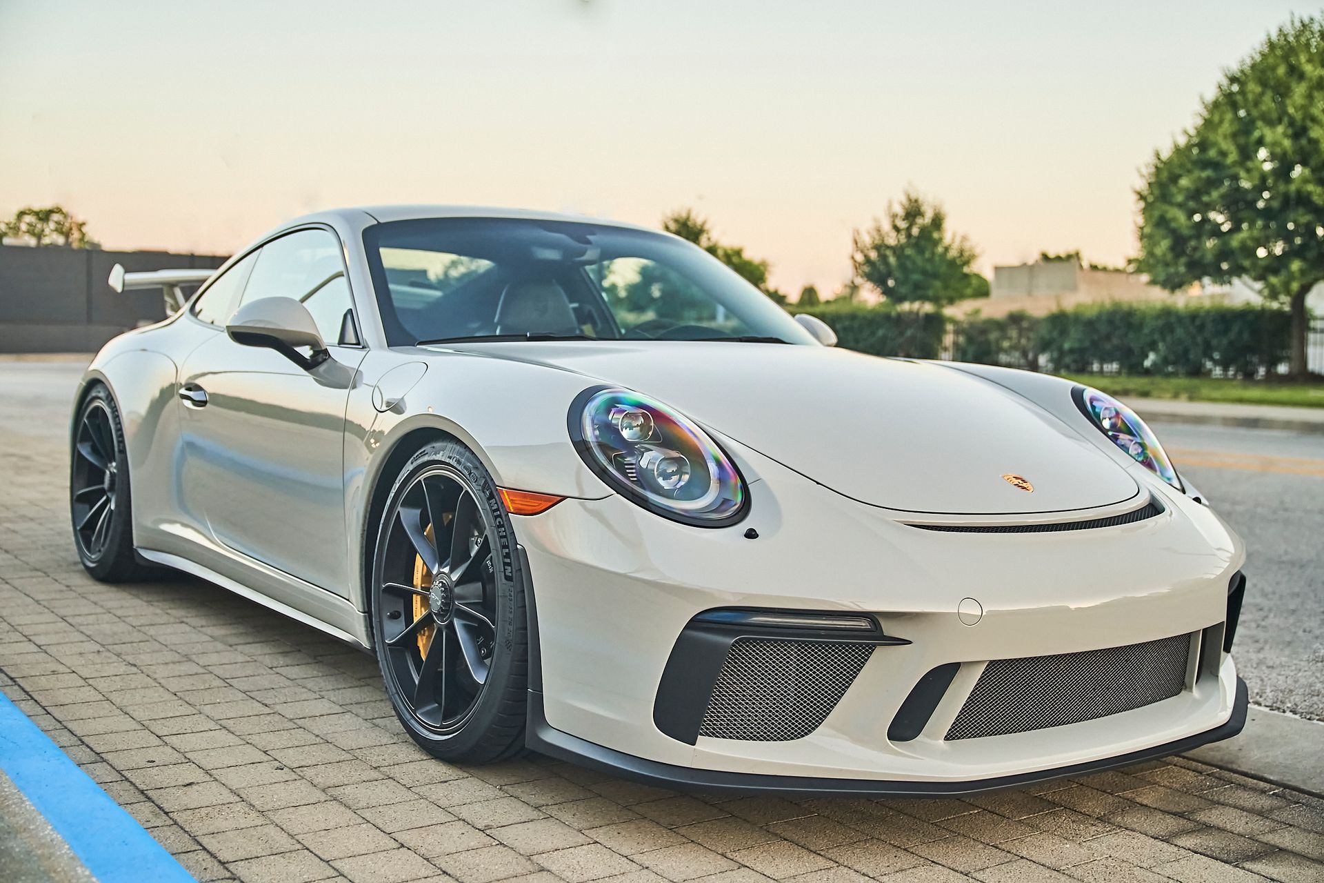 A white porsche 911 gt3 rs is parked in a parking lot.