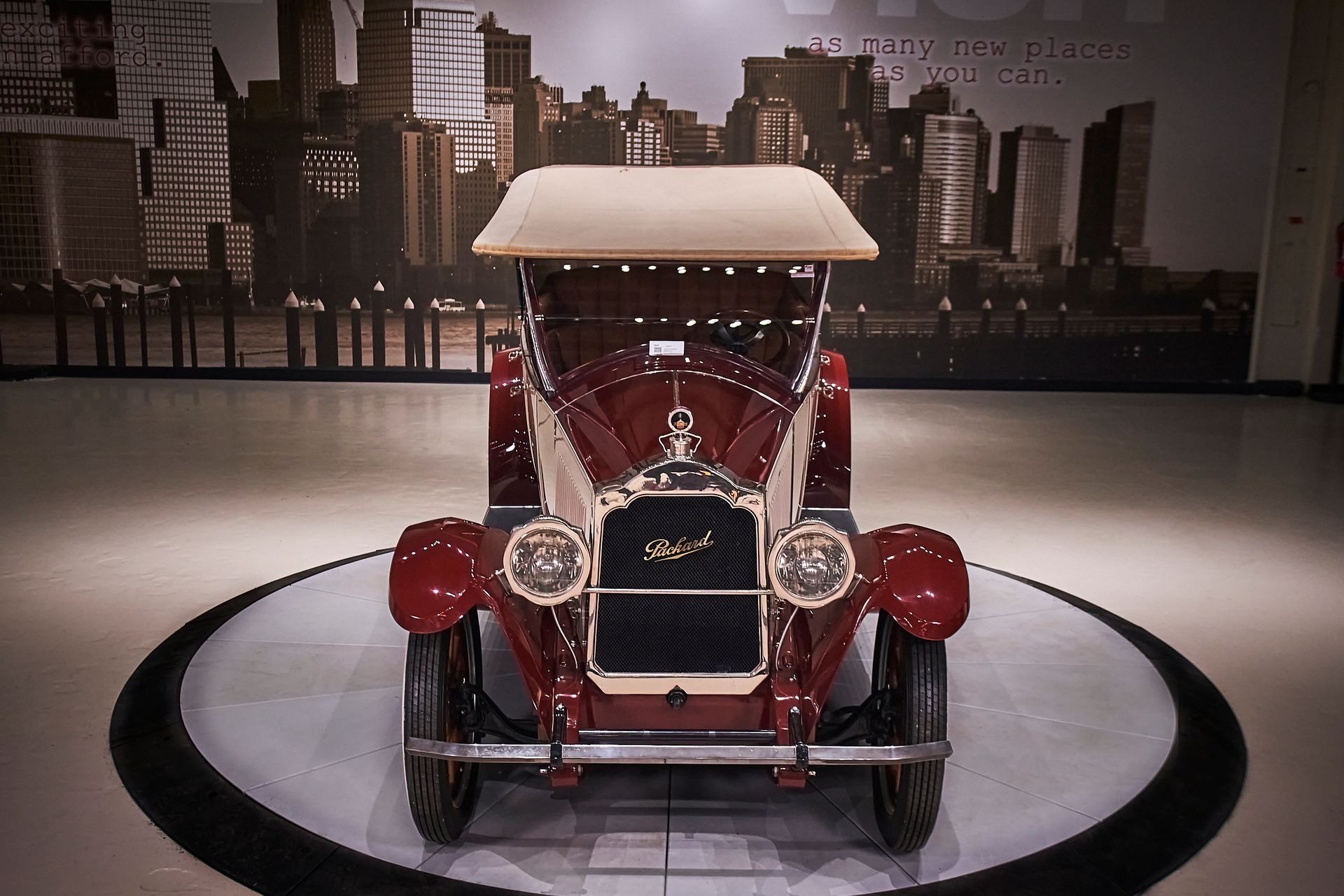 An old red car with a canopy is on display
