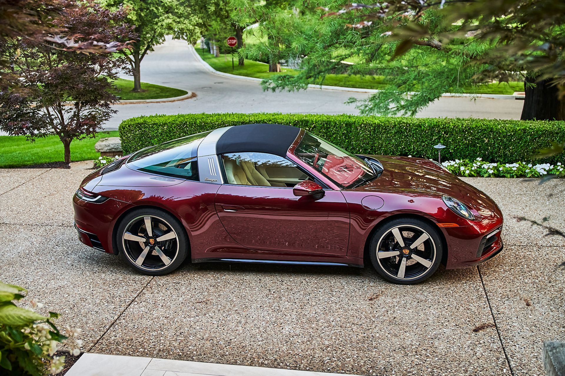 A red porsche targa is parked in a driveway.