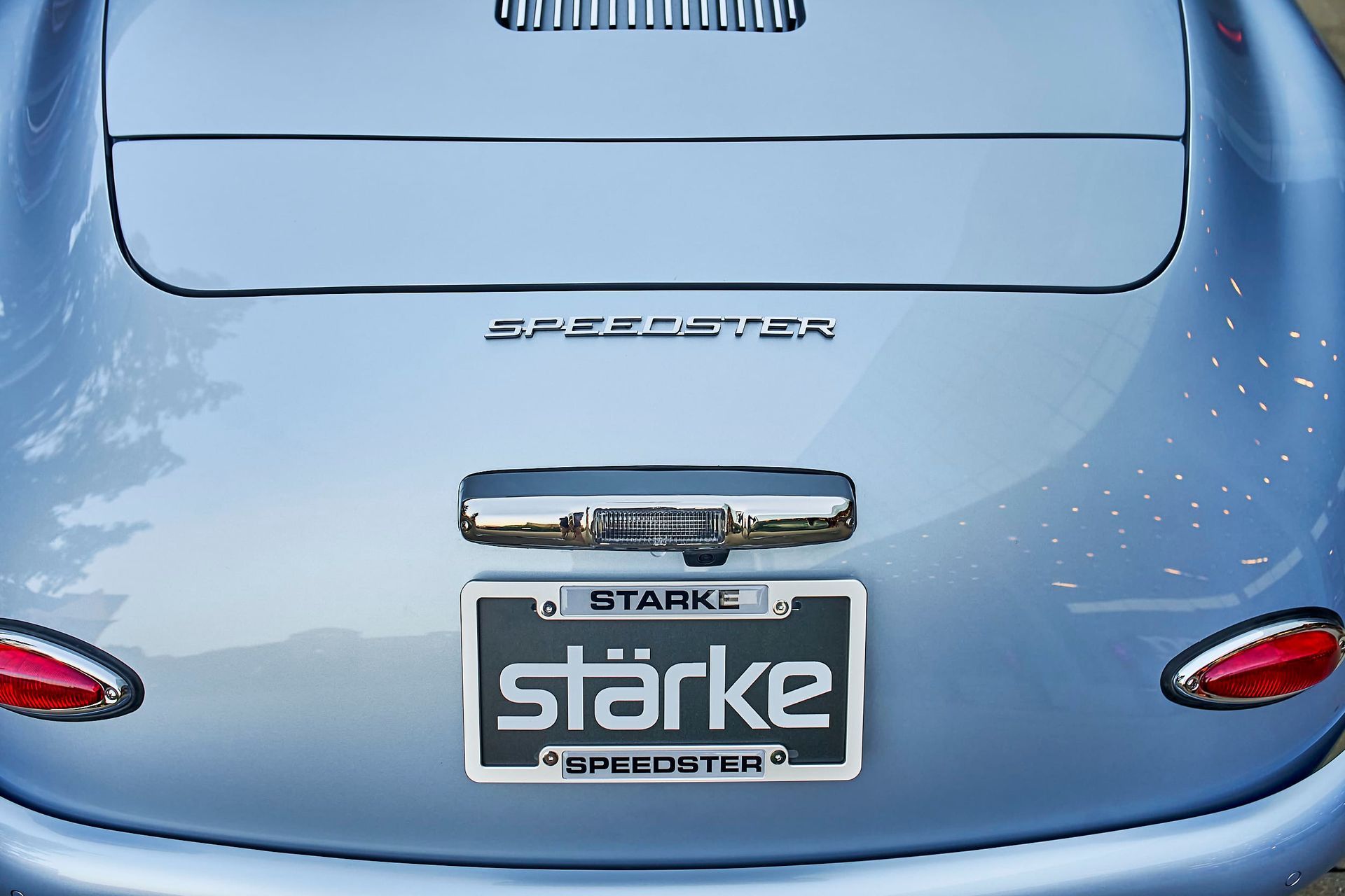 Rear view of a light blue Stärke Speedster, showcasing the license plate and rear lights. The car is parked outside.