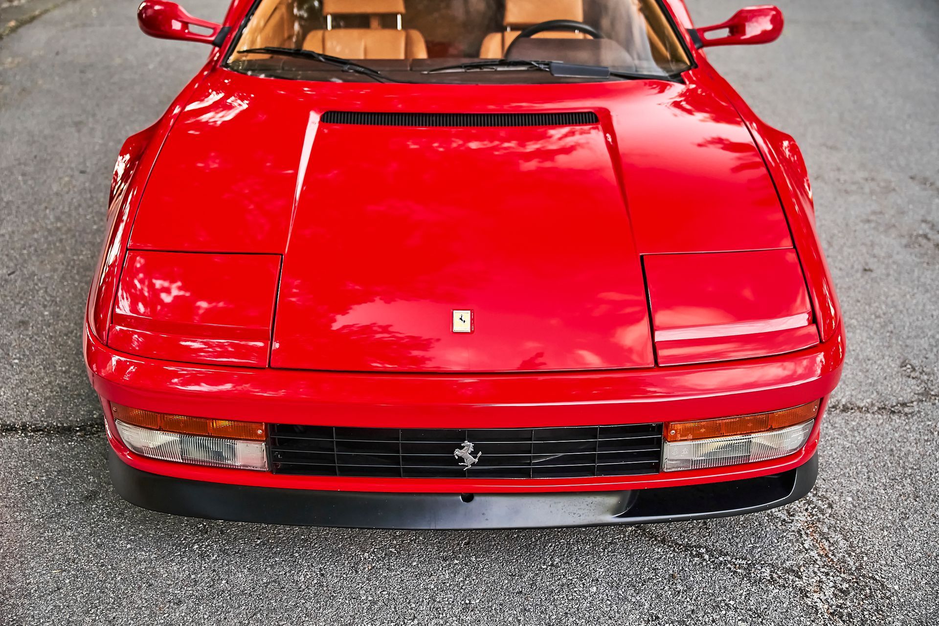 A red ferrari is parked on the side of the road