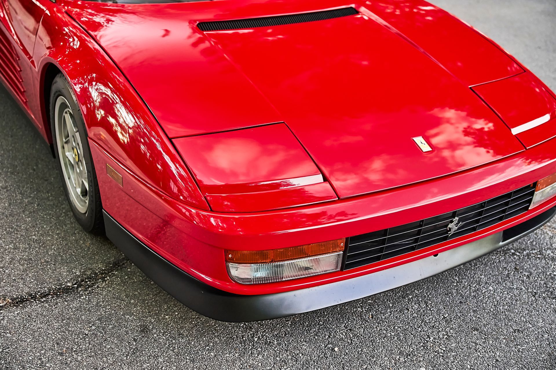 A red ferrari is parked on the side of the road.
