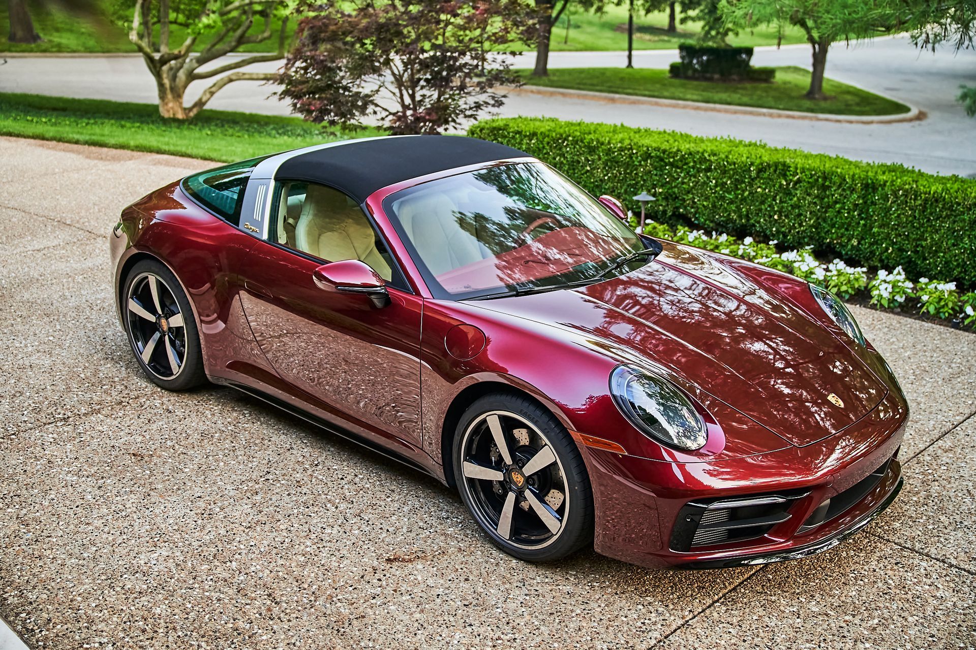 A red porsche targa is parked in a driveway.