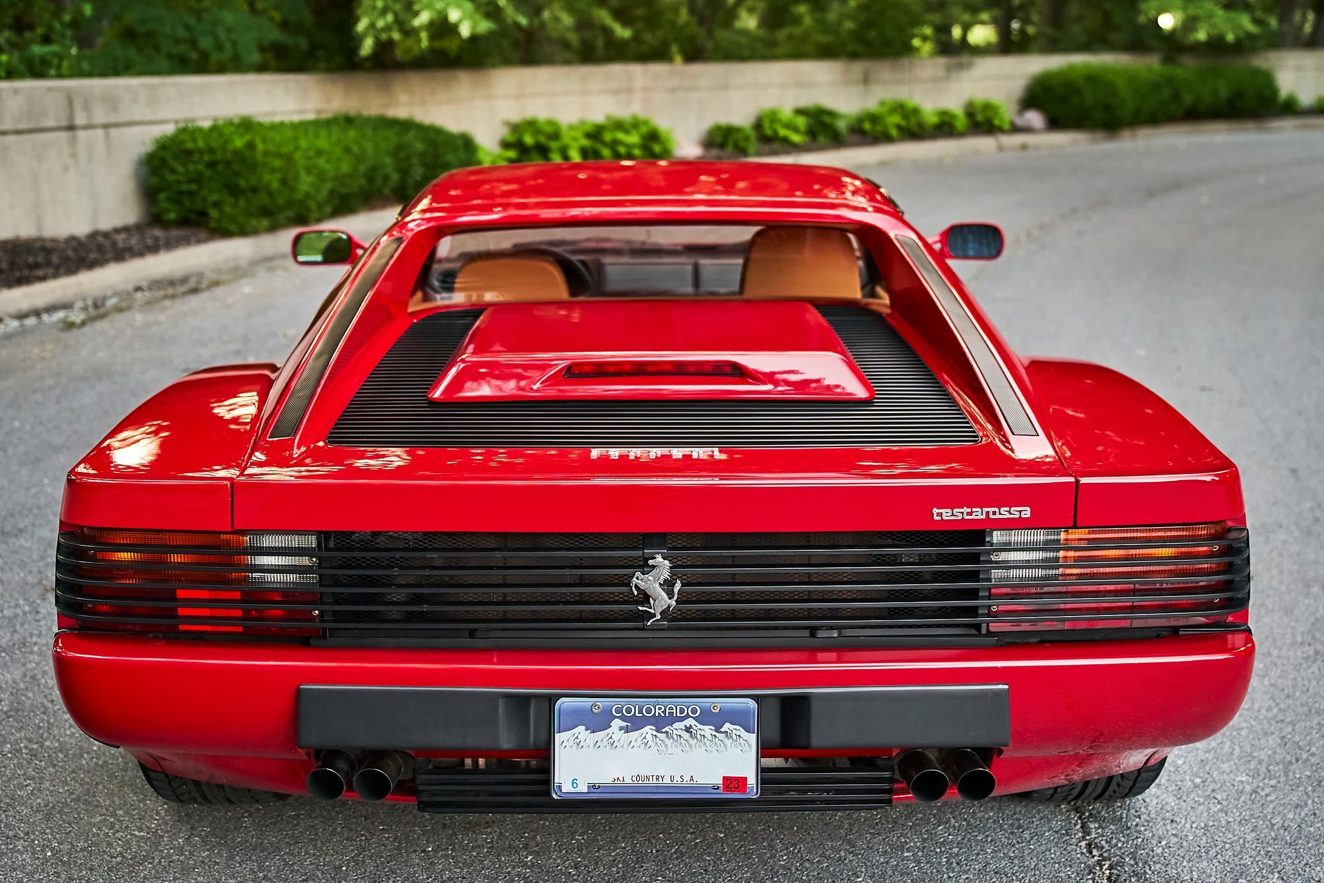 A red ferrari is parked on the side of the road