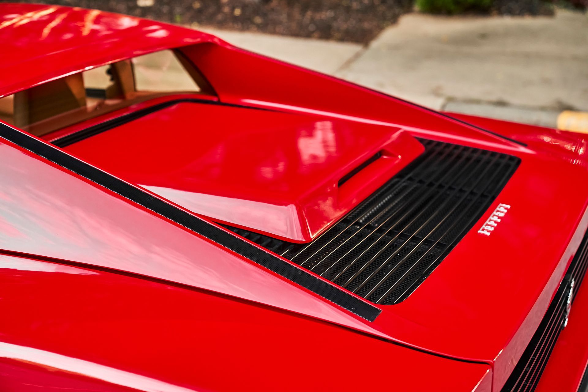 A close up of the hood of a red sports car.