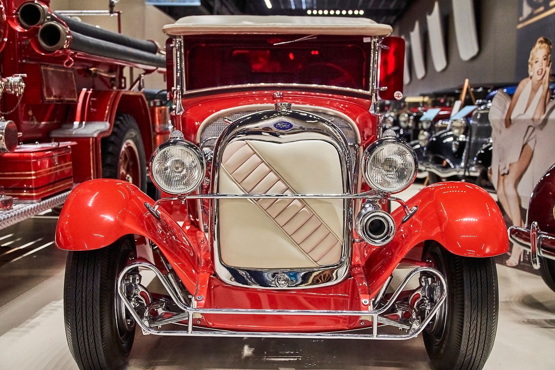 A red car is parked in front of a fire truck