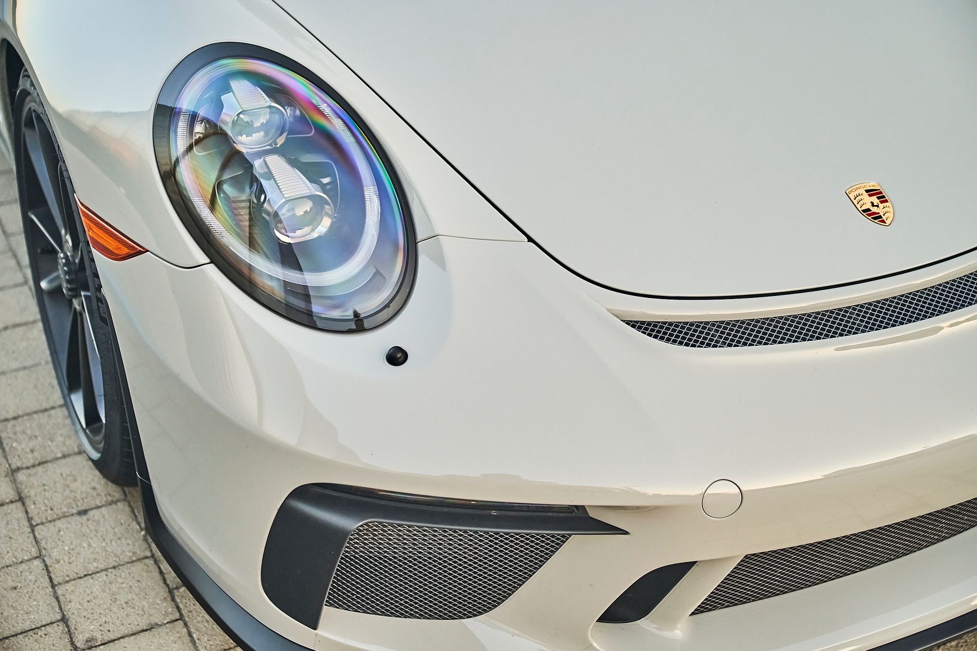 A close up of the front of a white porsche 911 gt3 rs.