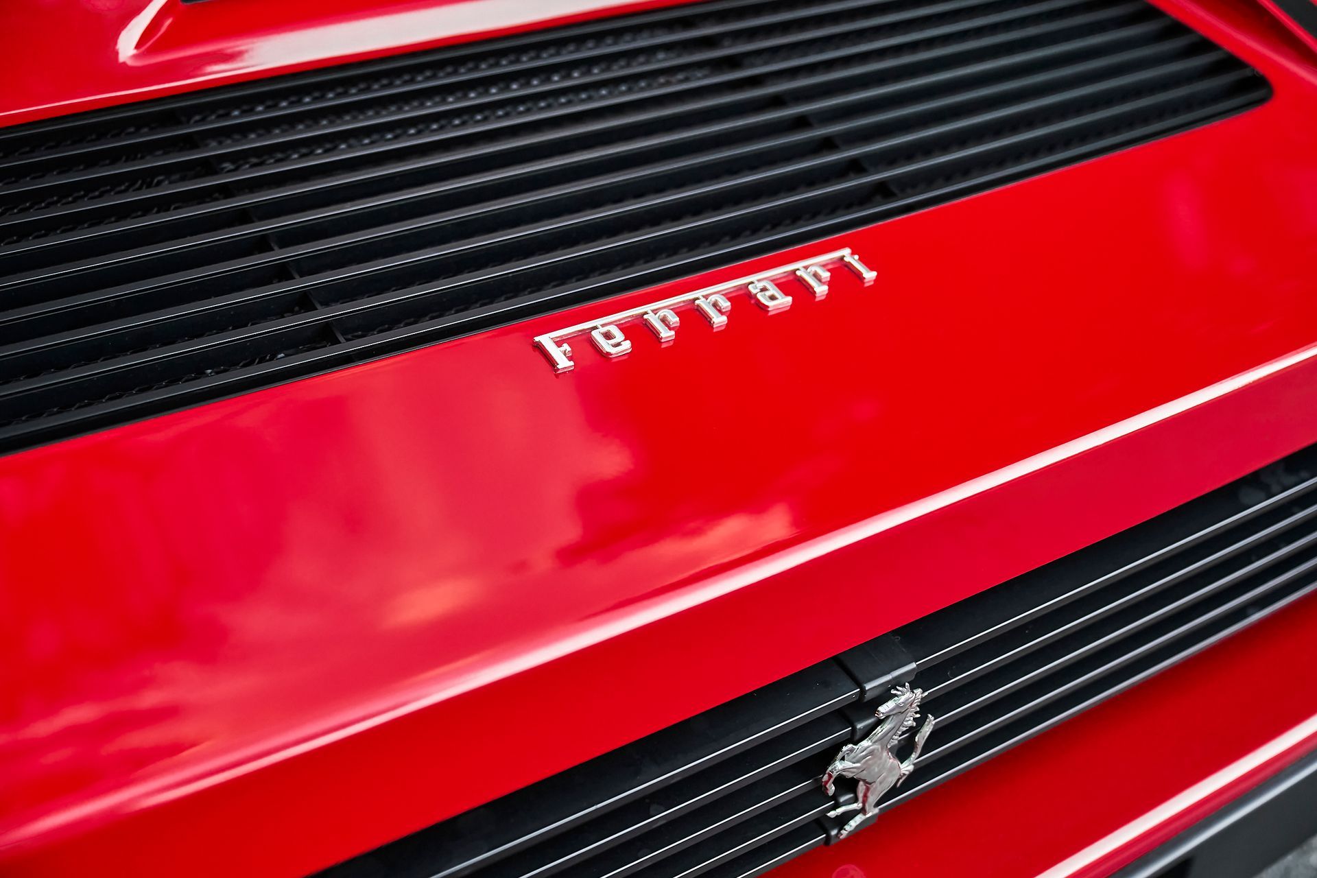 A close up of the hood of a red ferrari car.