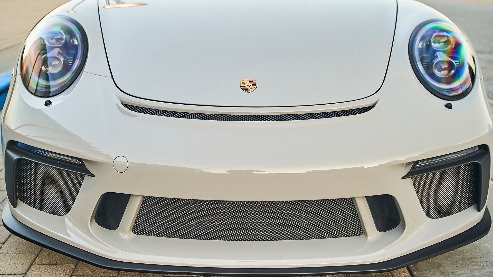 A white porsche 911 gt3 rs is parked on the side of the road.