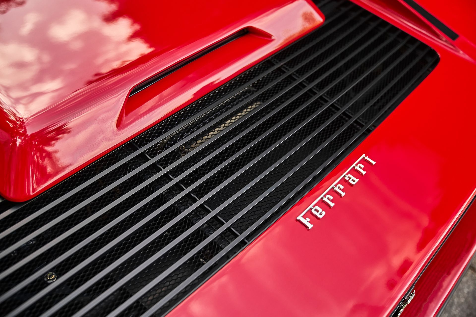 A close up of the hood of a red ferrari.