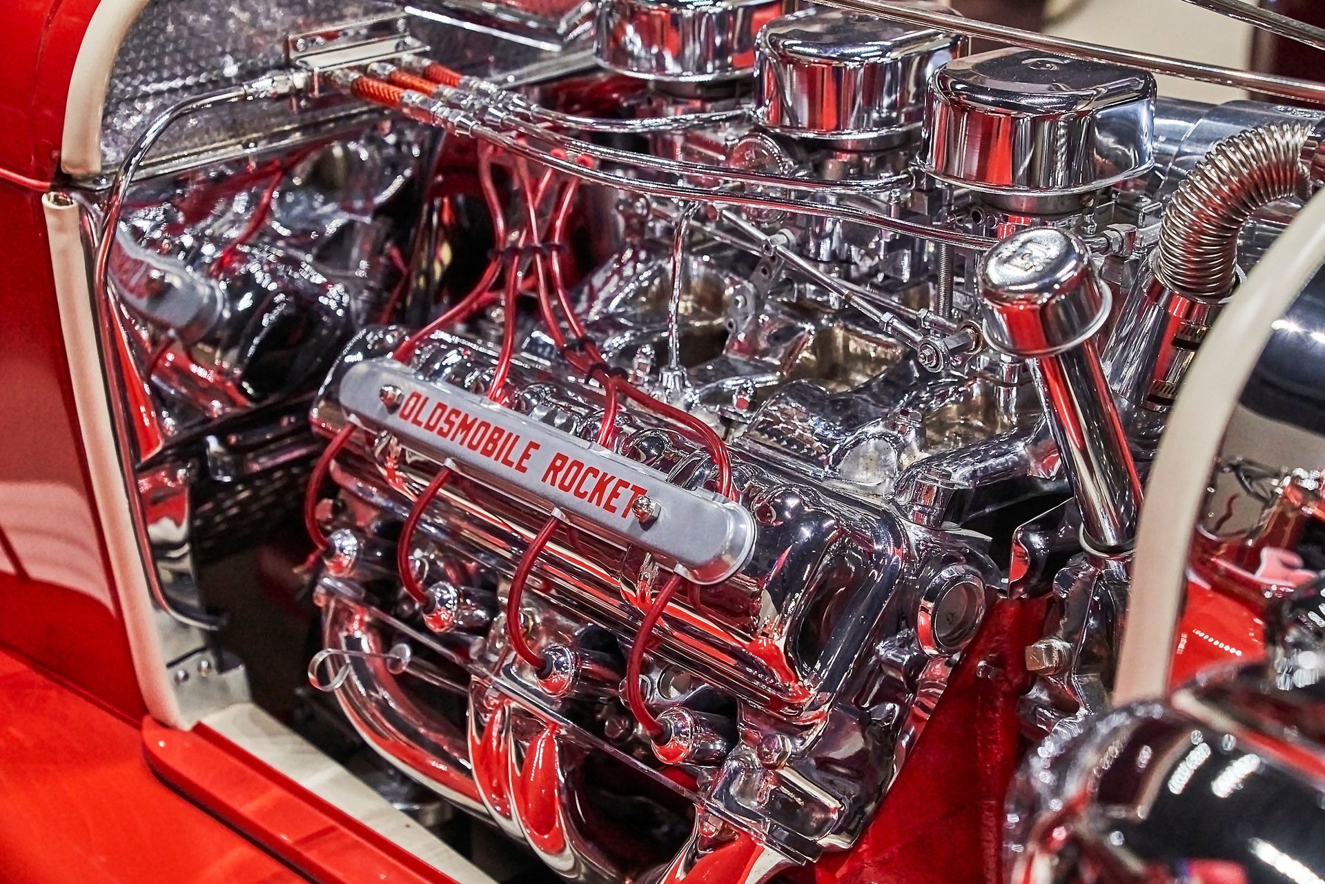 A close up of a chrome engine in a red car