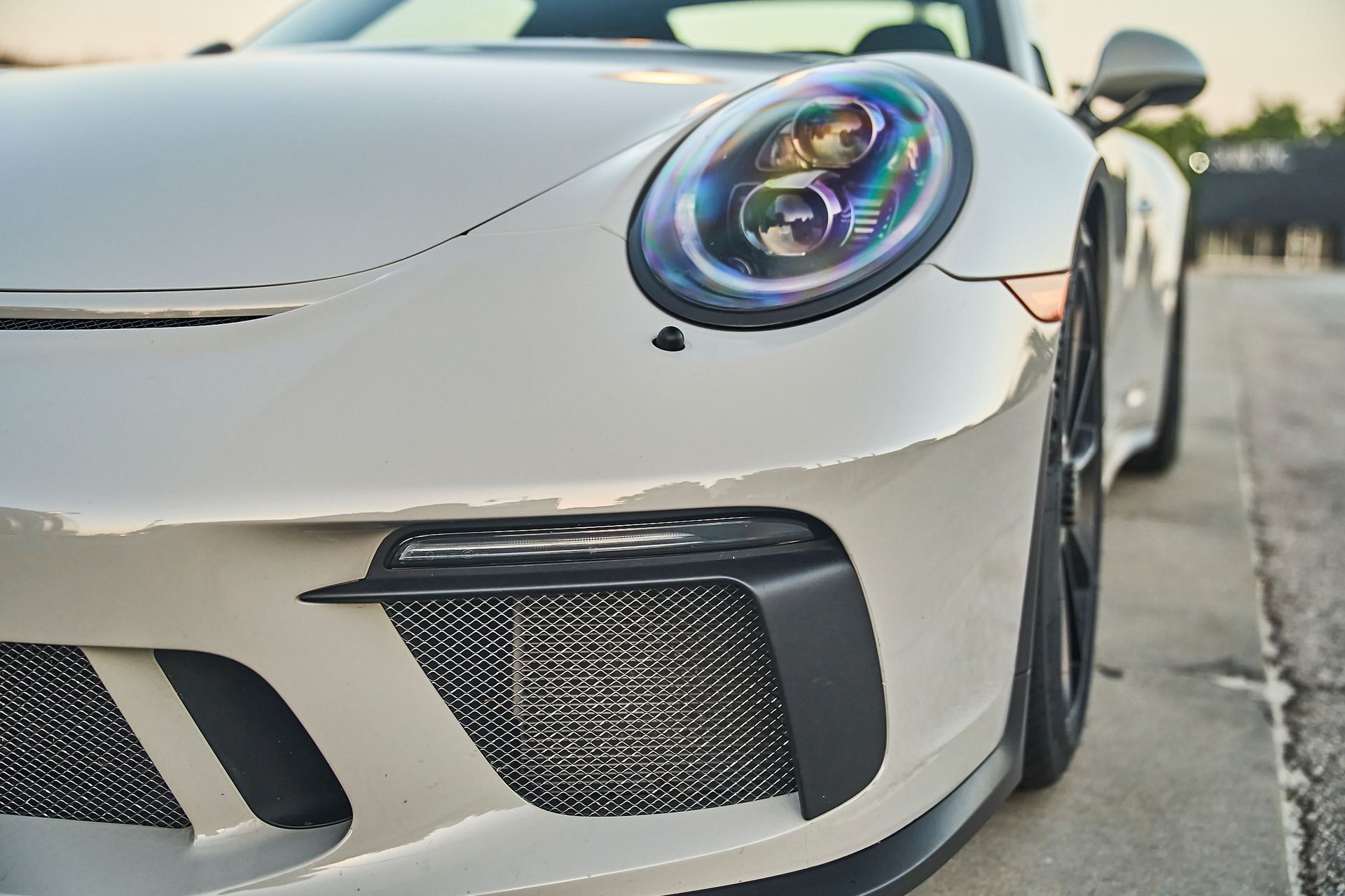 A close up of the front of a white sports car