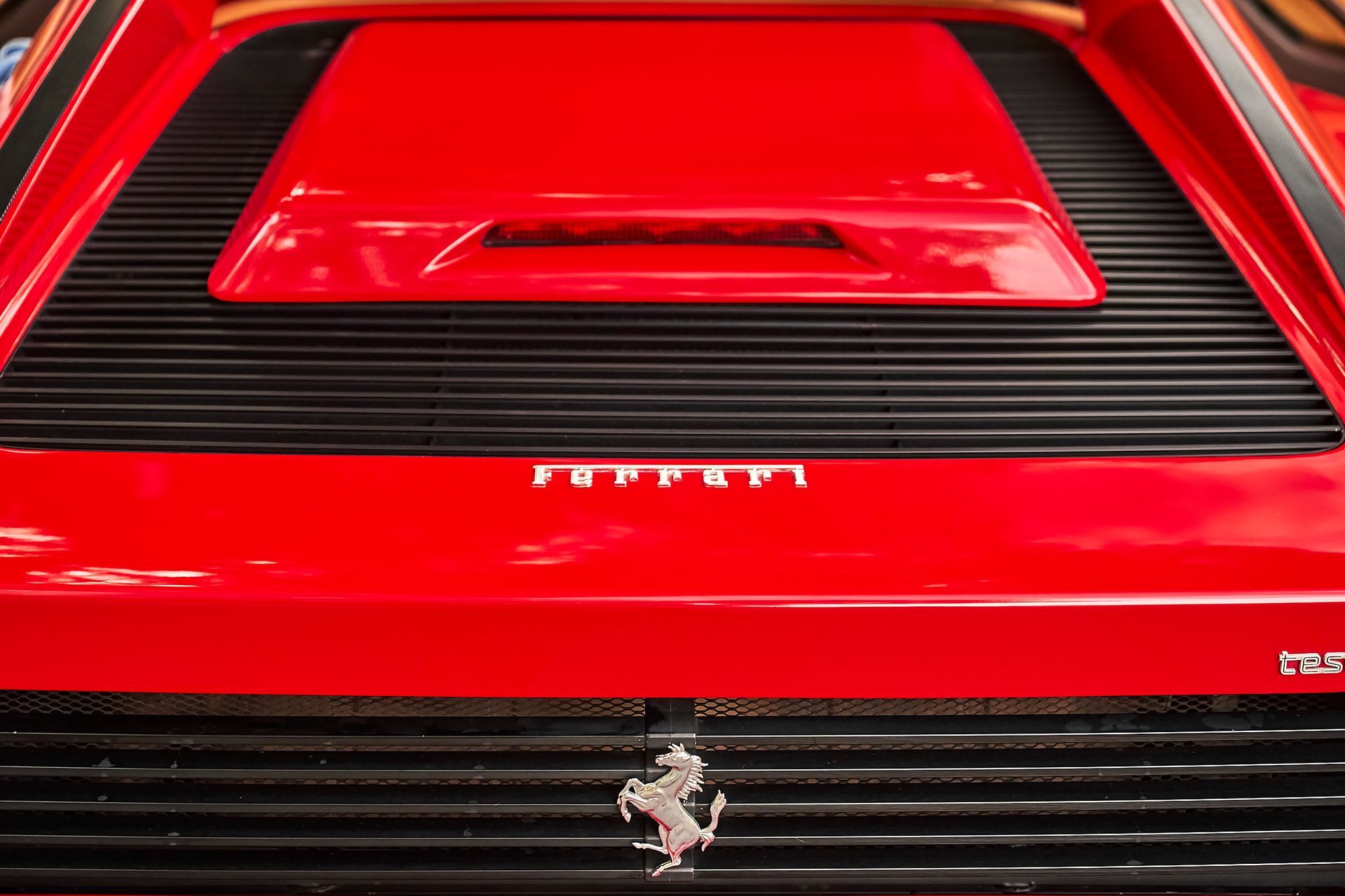 A close up of the hood of a red ferrari sports car.