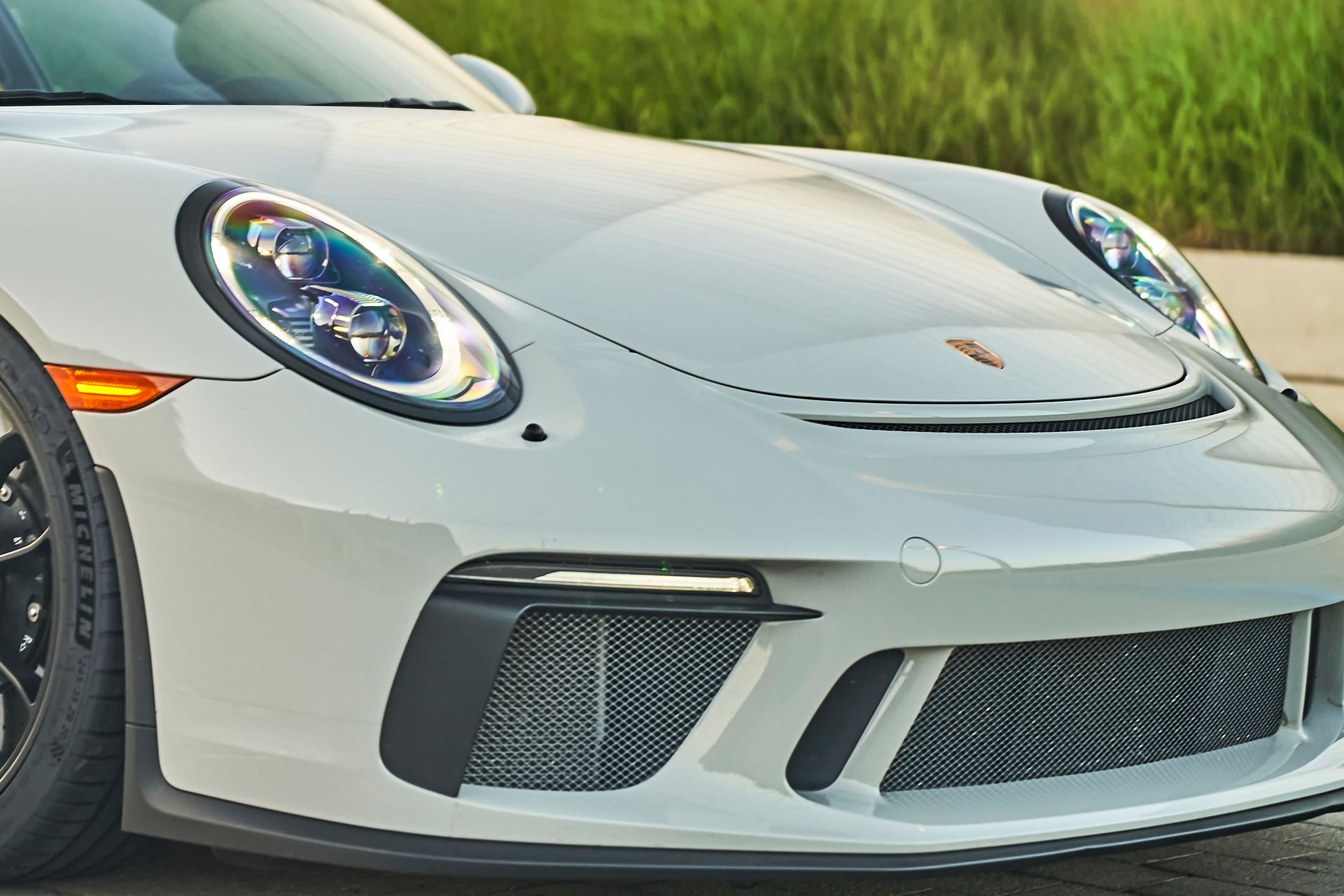 A white porsche 911 gt3 rs is parked on the side of the road.