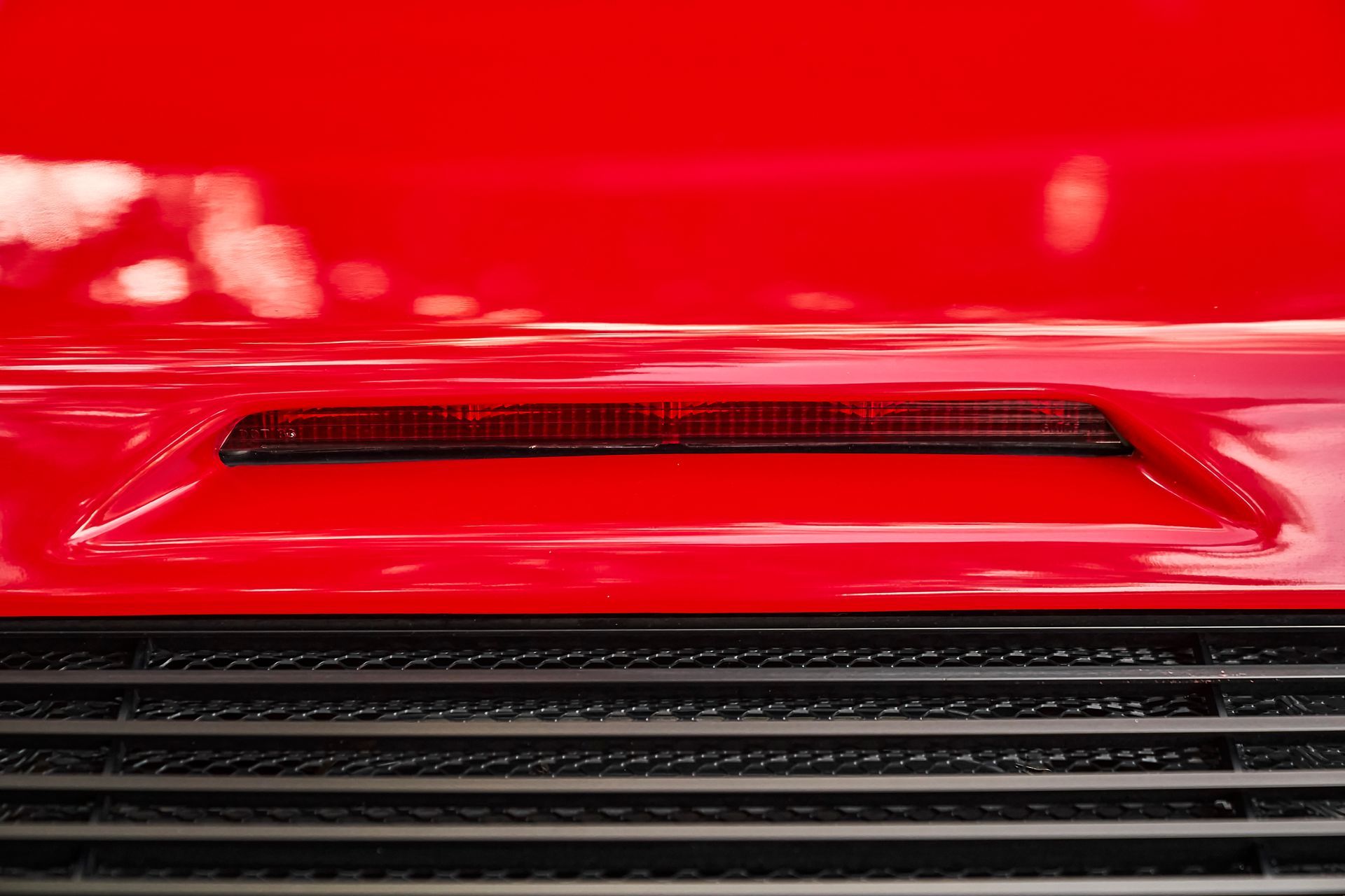 A close up of the hood of a red car.