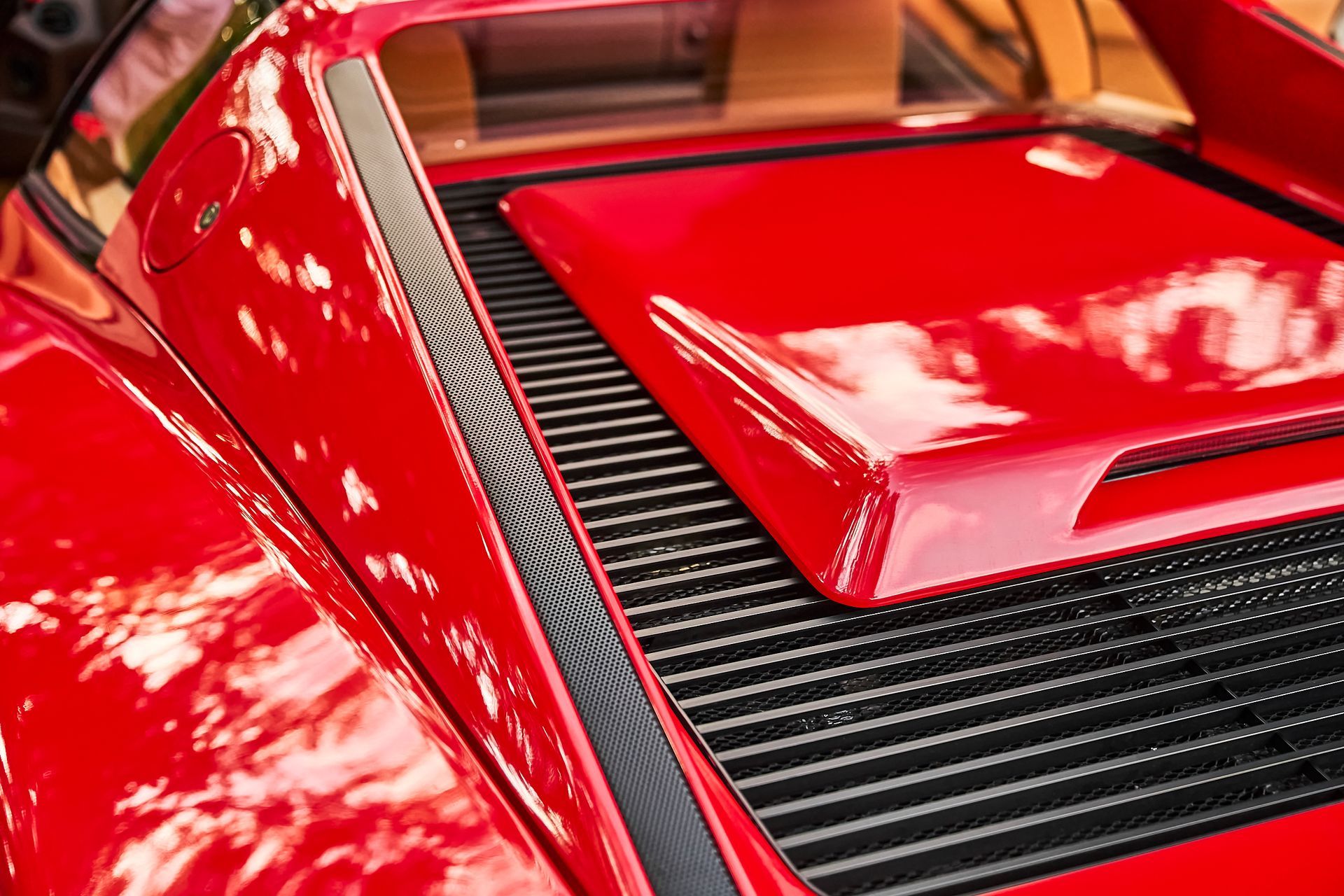 A close up of the hood of a red sports car