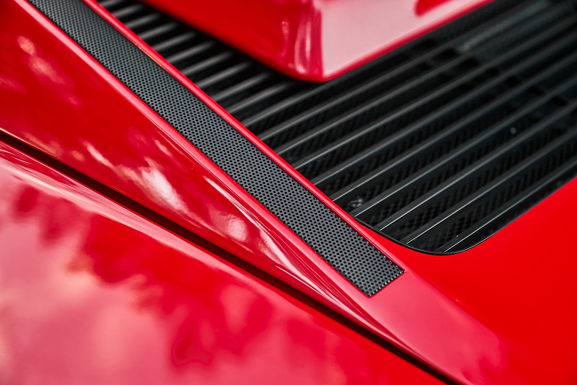 A close up of the hood of a red car