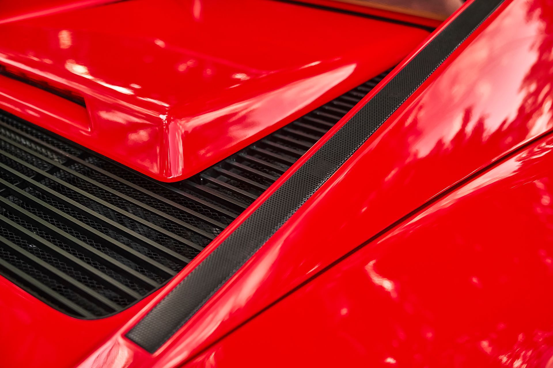 A close up of the hood of a red sports car.