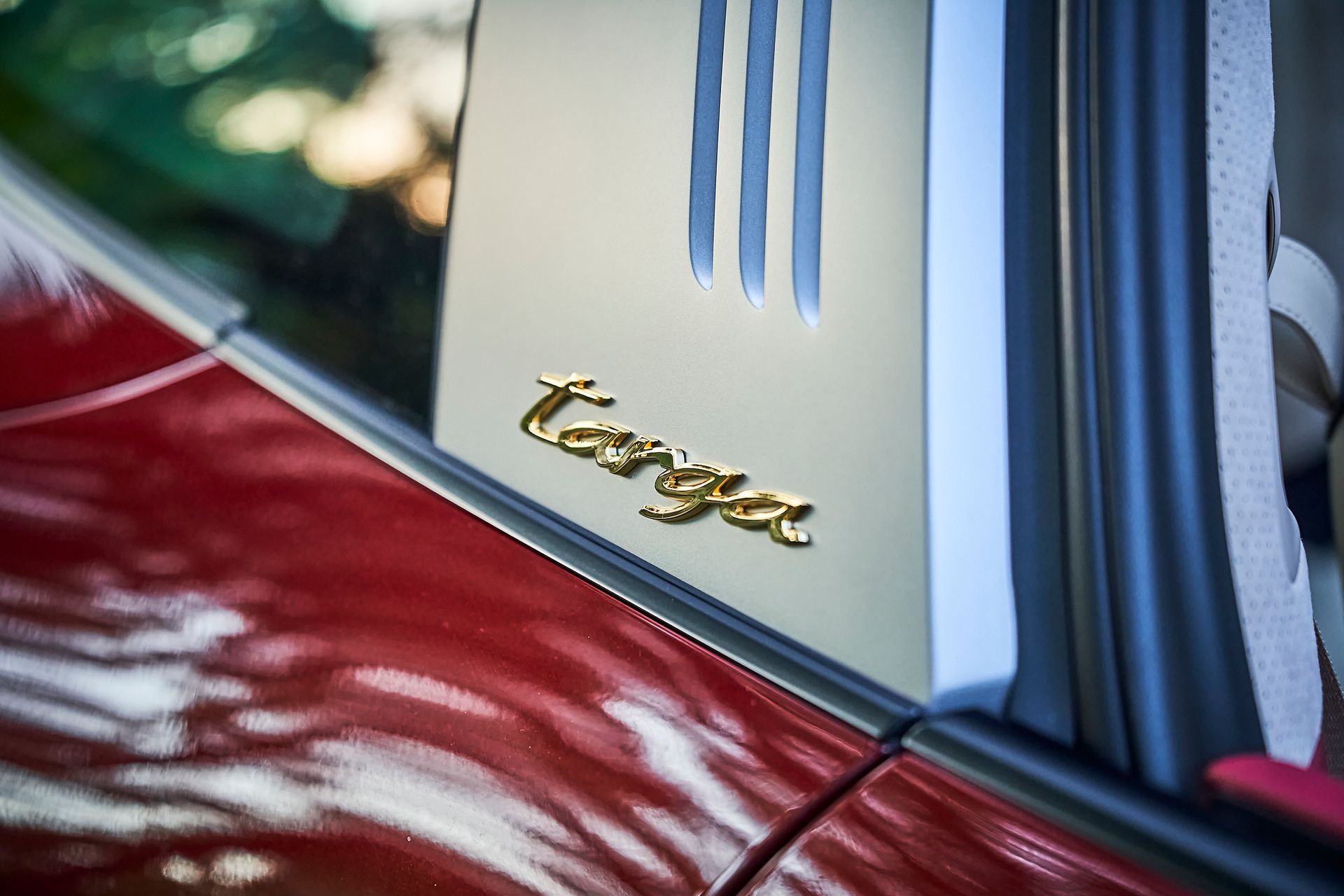 A close up of the side of a red porsche targa