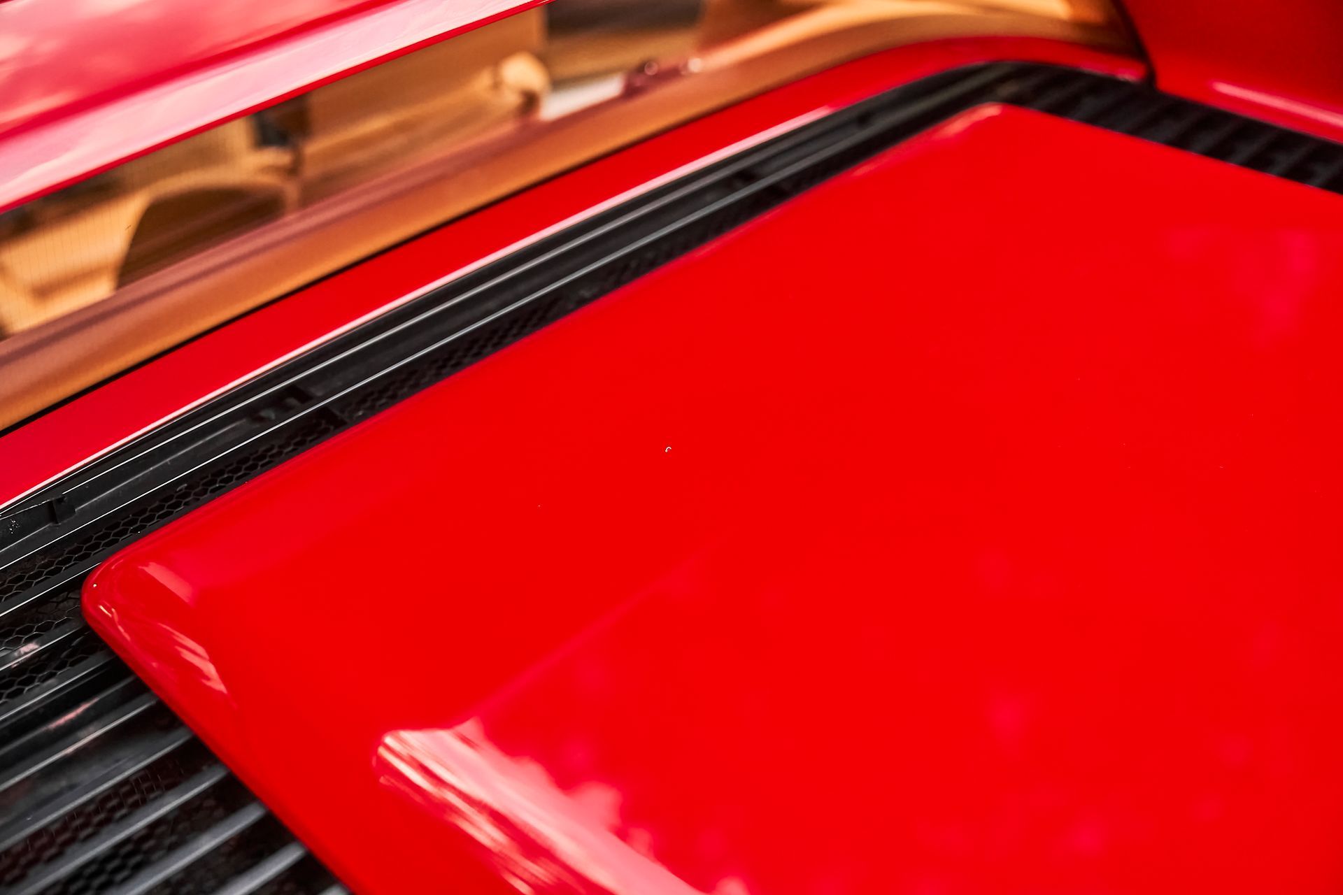 A close up of the hood of a red car.
