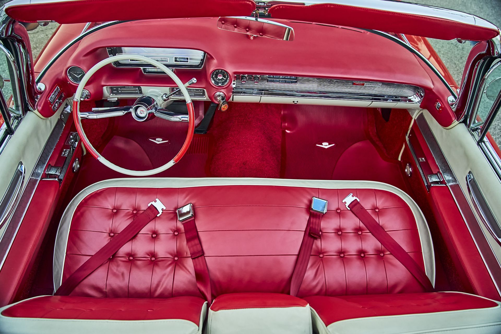 A red and white car with a steering wheel and seat belts