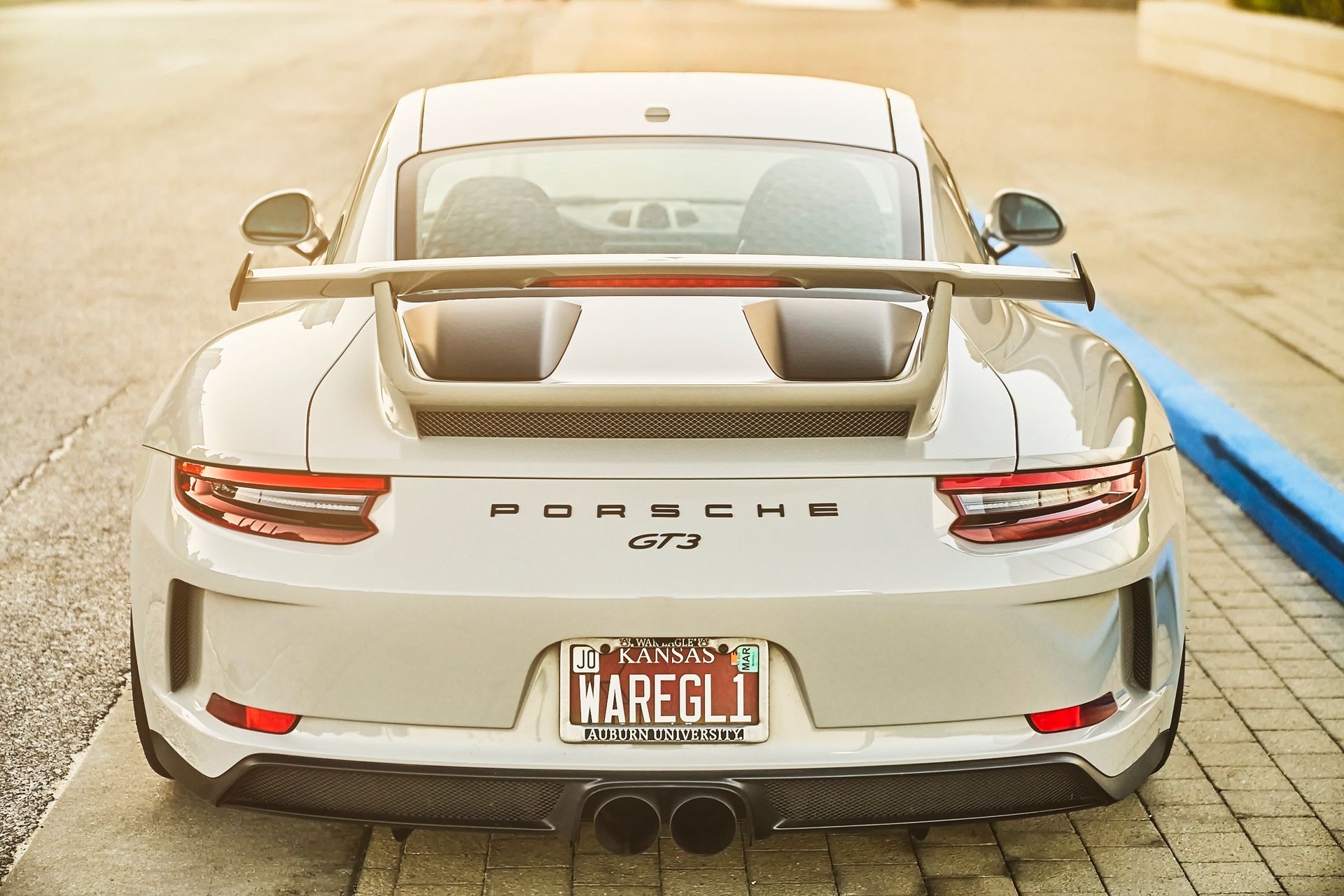 A white porsche 911 gt3 rs is parked on the side of the road.