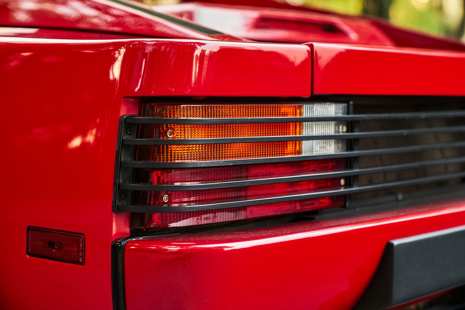 A close up of a red sports car 's tail light.