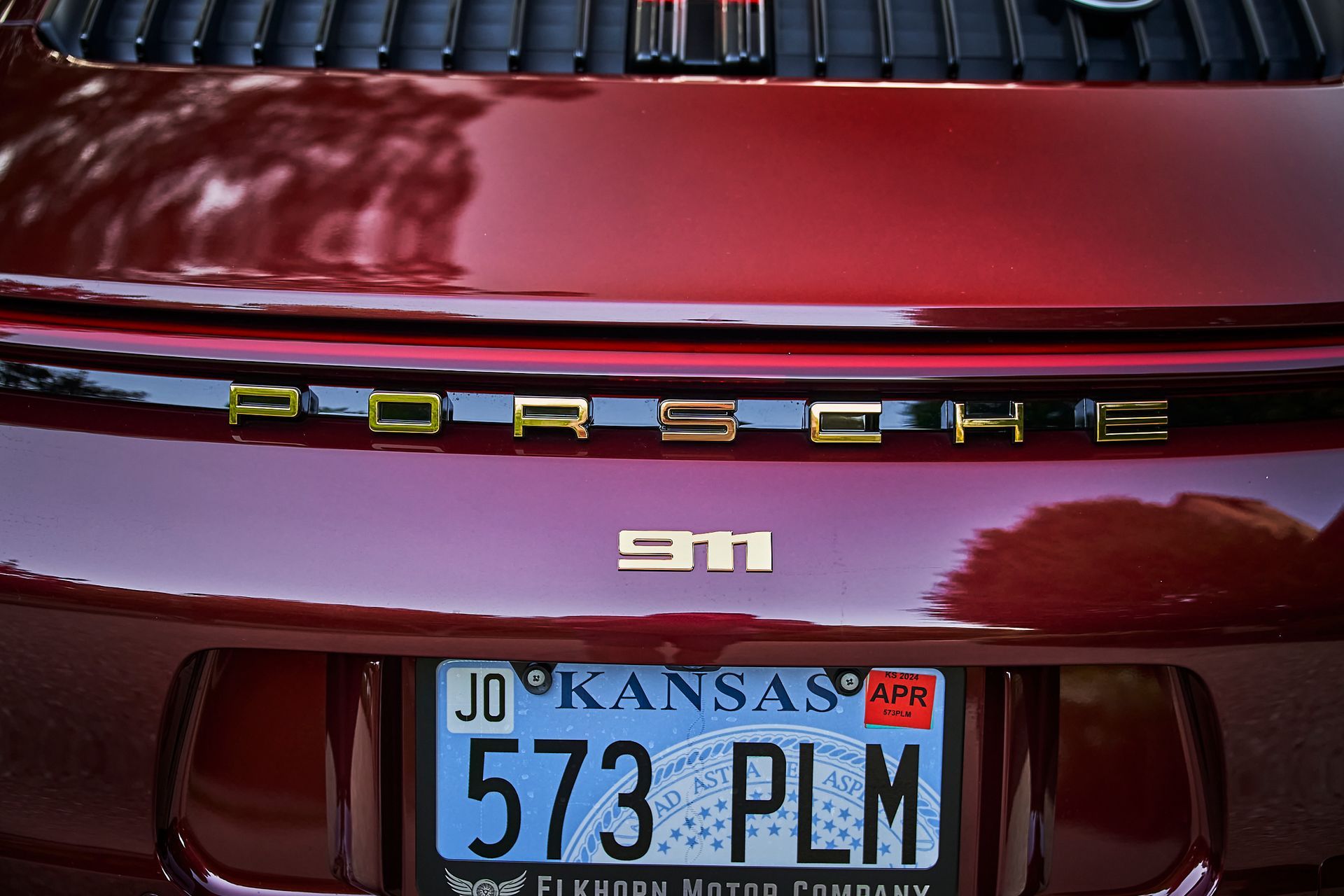 A red porsche 911 with a kansas license plate