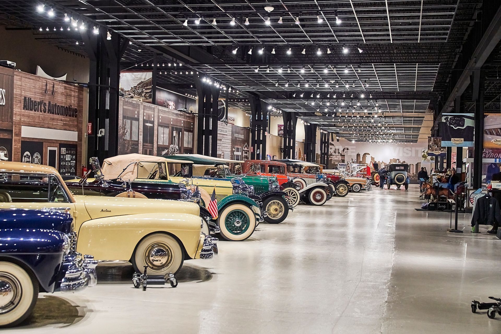 A row of old cars are parked in a museum.