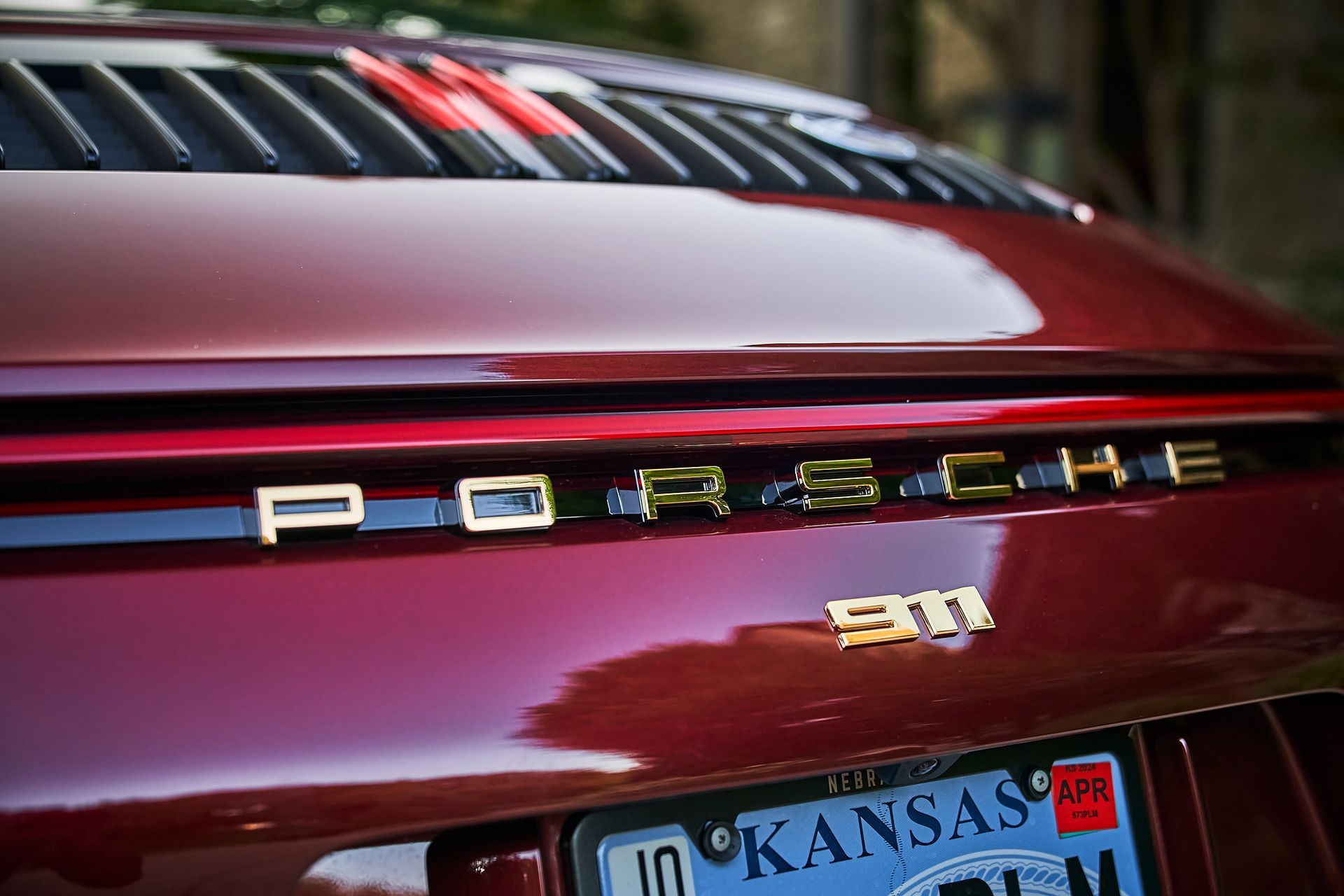 A red porsche 911 with a kansas license plate