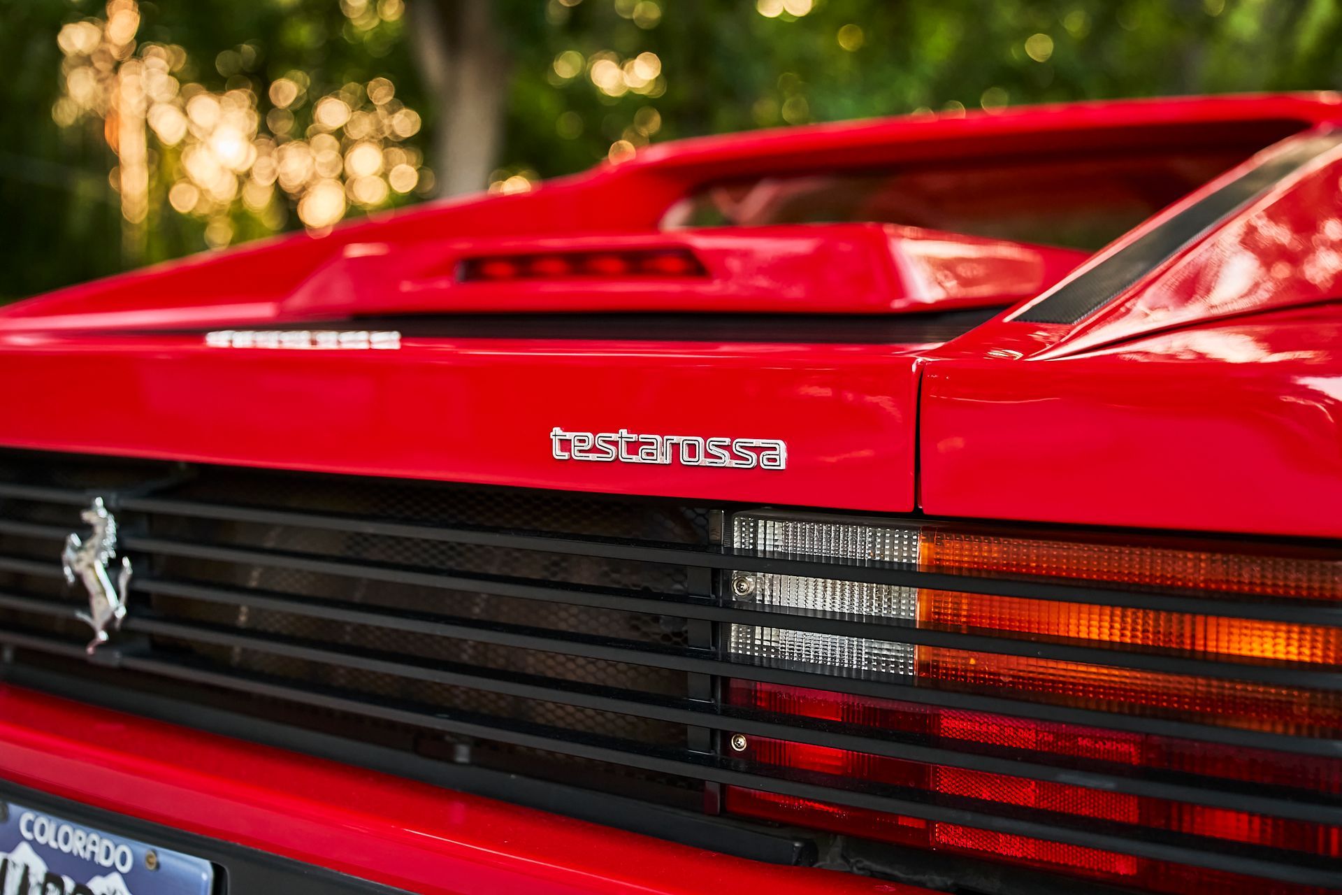 A close up of the front of a red ferrari testarossa.